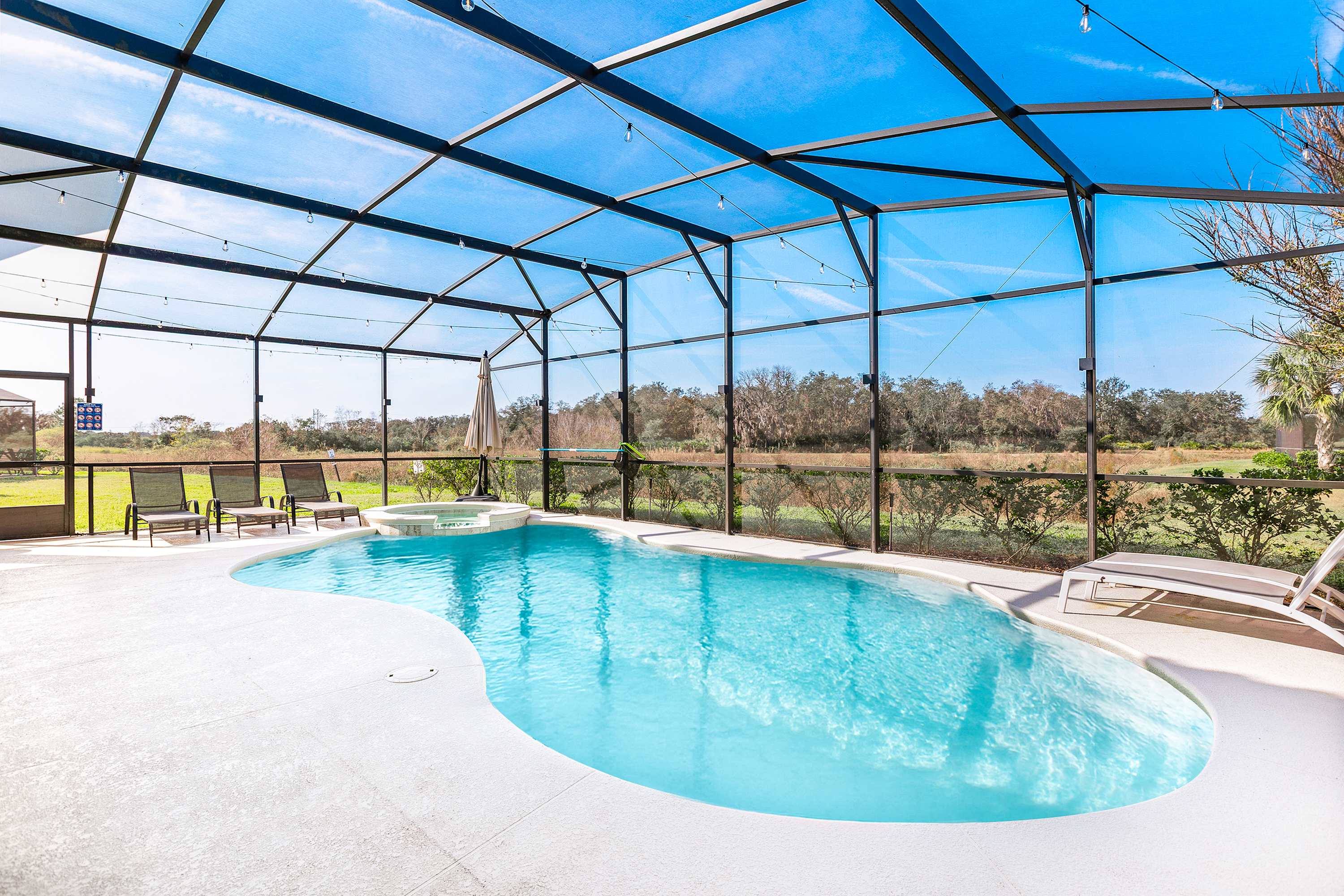Spacious screened-in pool area with open views and plenty of sunlight.