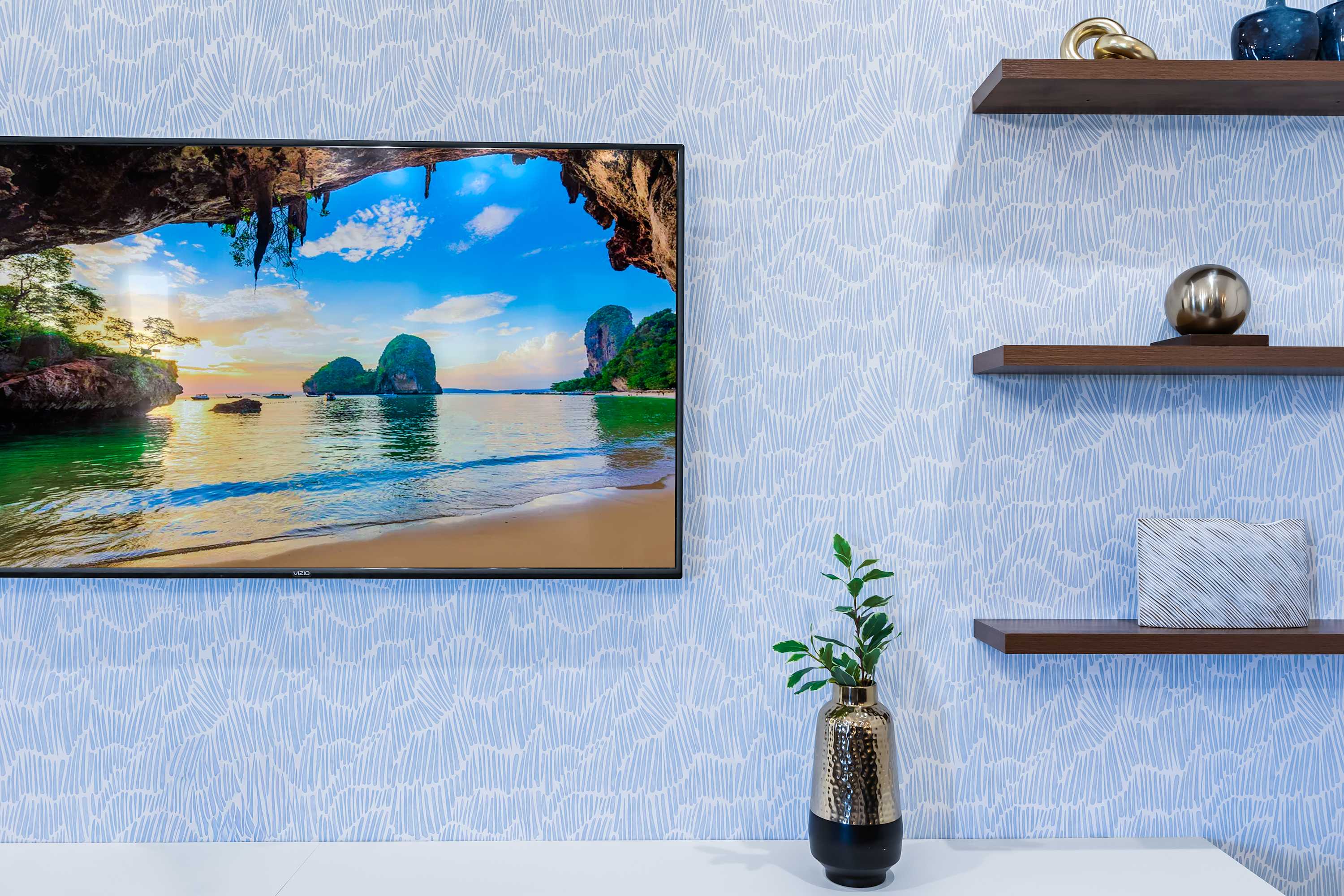 Wall-mounted TV with stylish accent shelving in the living area.