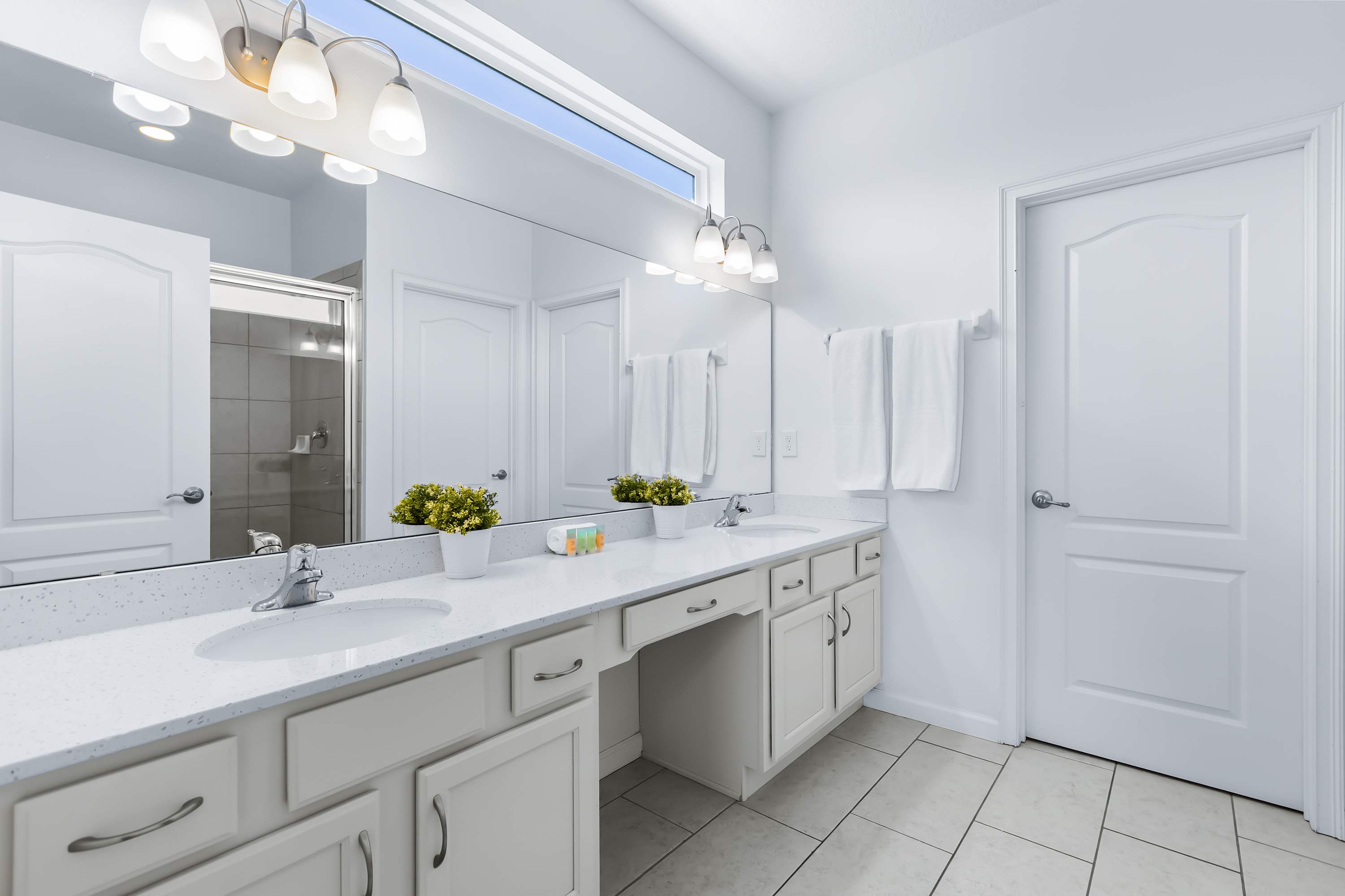 Spacious bathroom with double vanity and bright lighting.