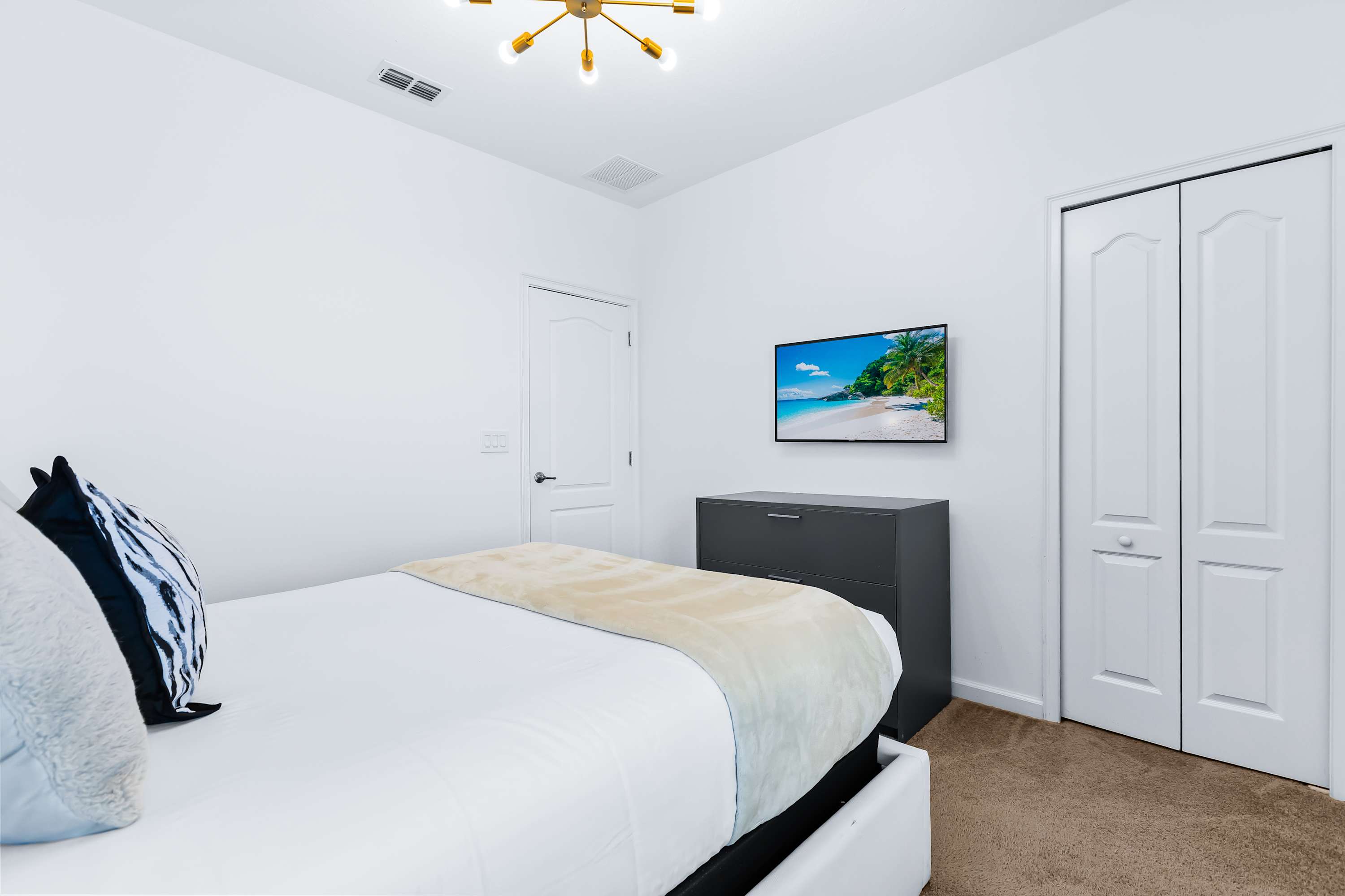 Bedroom with TV, cozy bedding, and minimalist design.