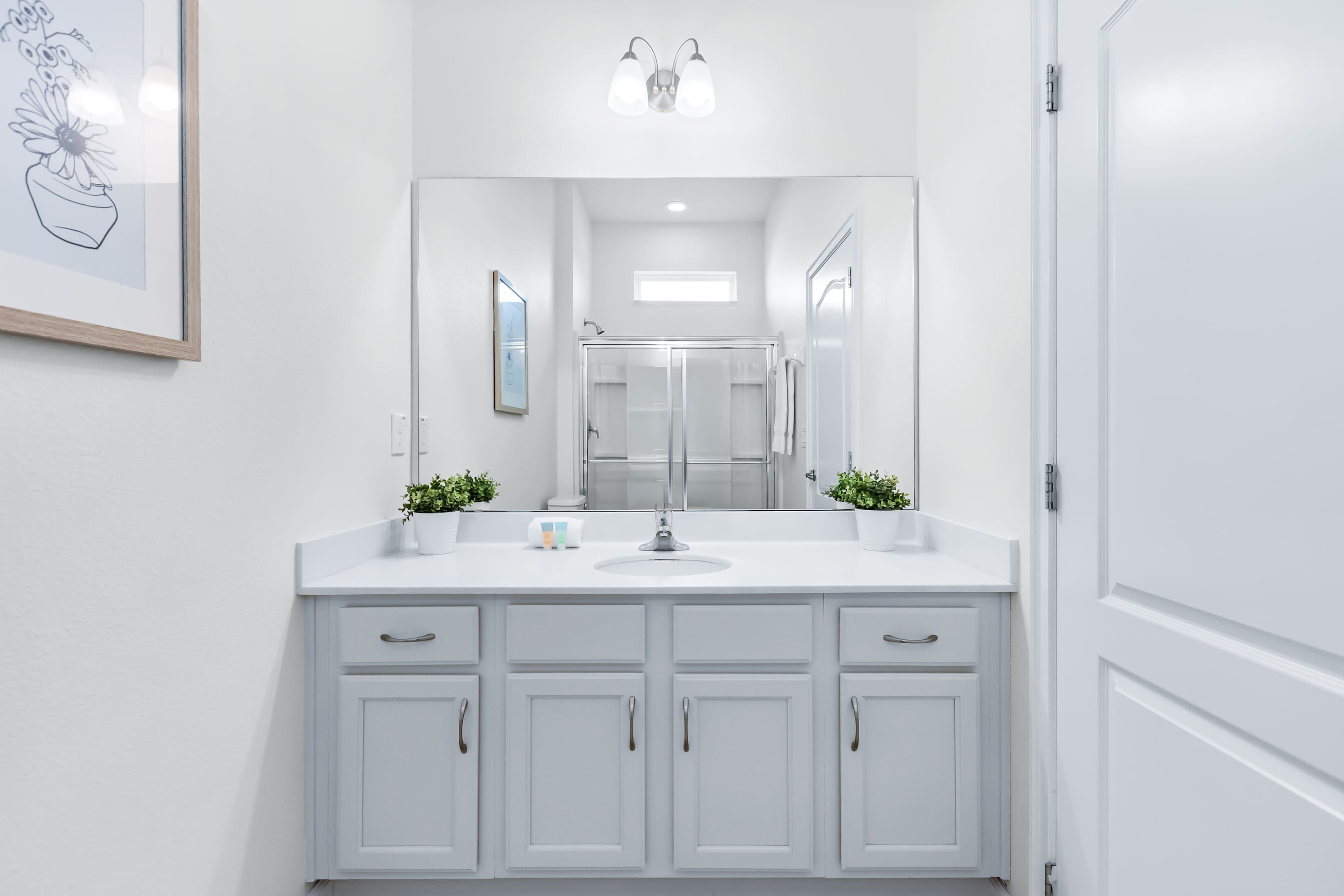 Spacious bathroom with vanity and bright lighting.