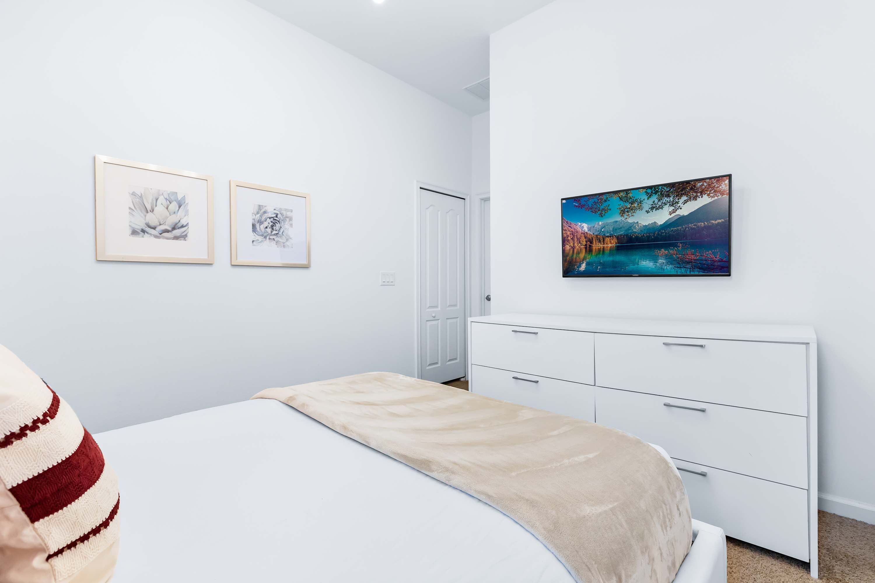 Bedroom with TV, cozy bedding, and minimalist design.