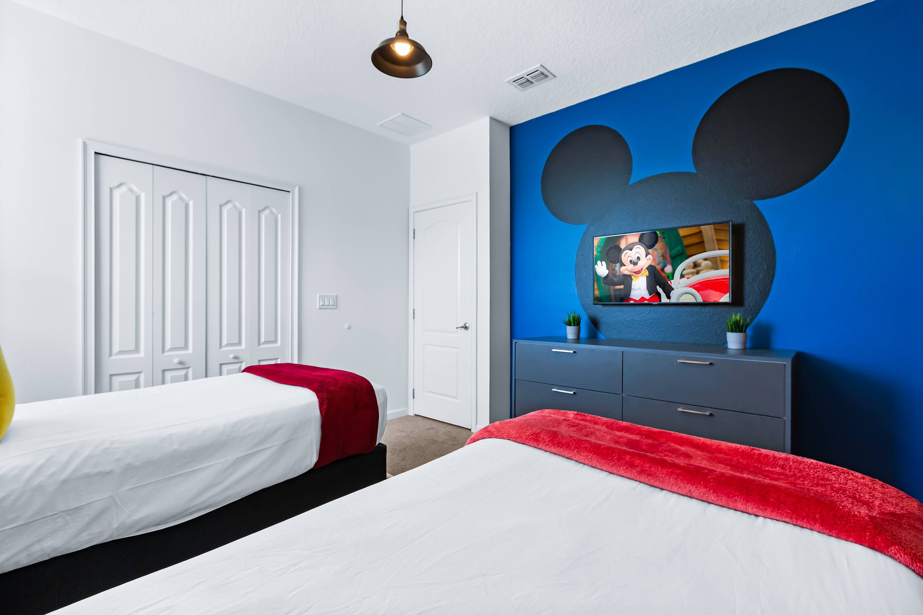 Fun Mickey themed bedroom with colorful design and cozy beds.