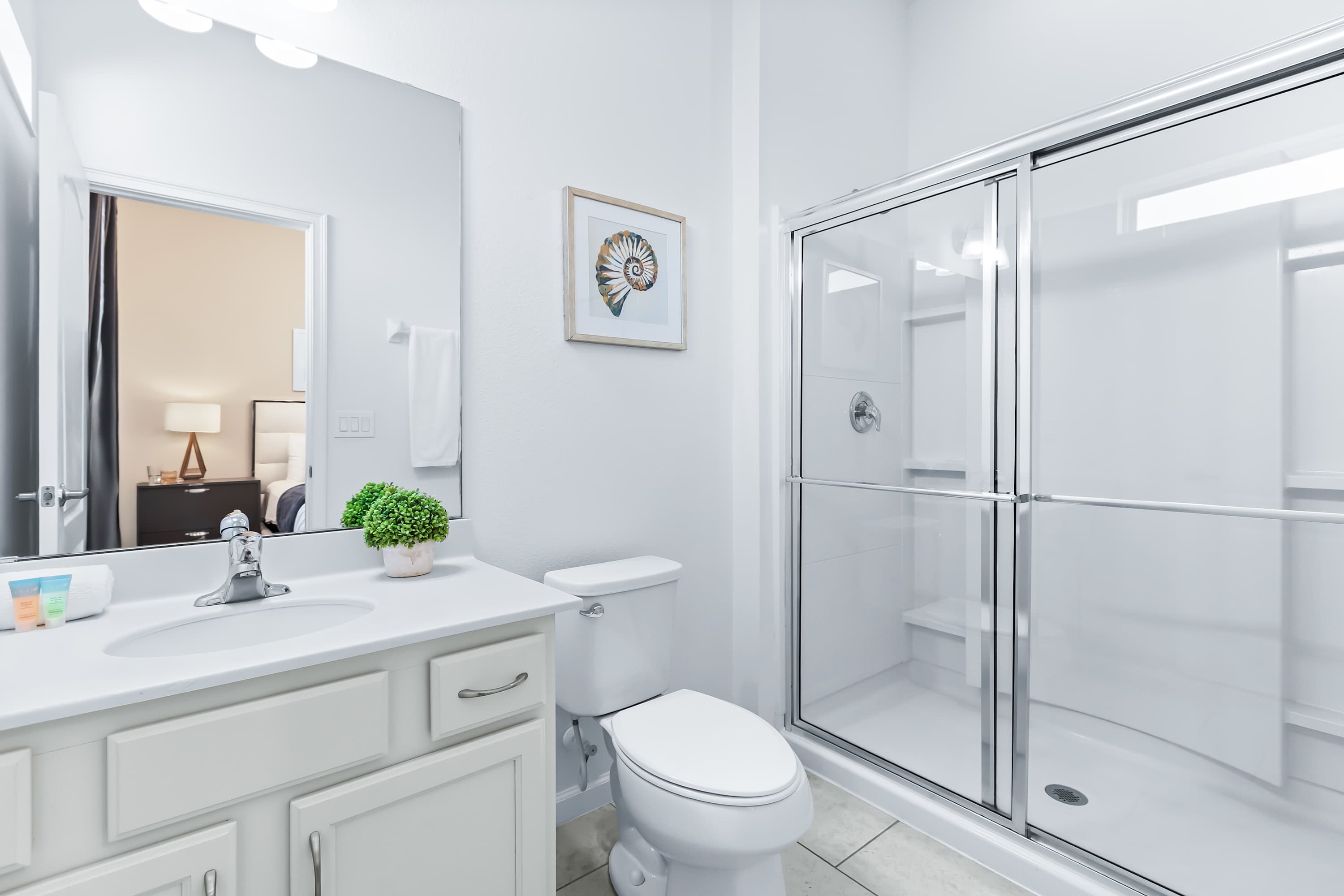 Ensuite bathroom with glass shower and bright double vanity.