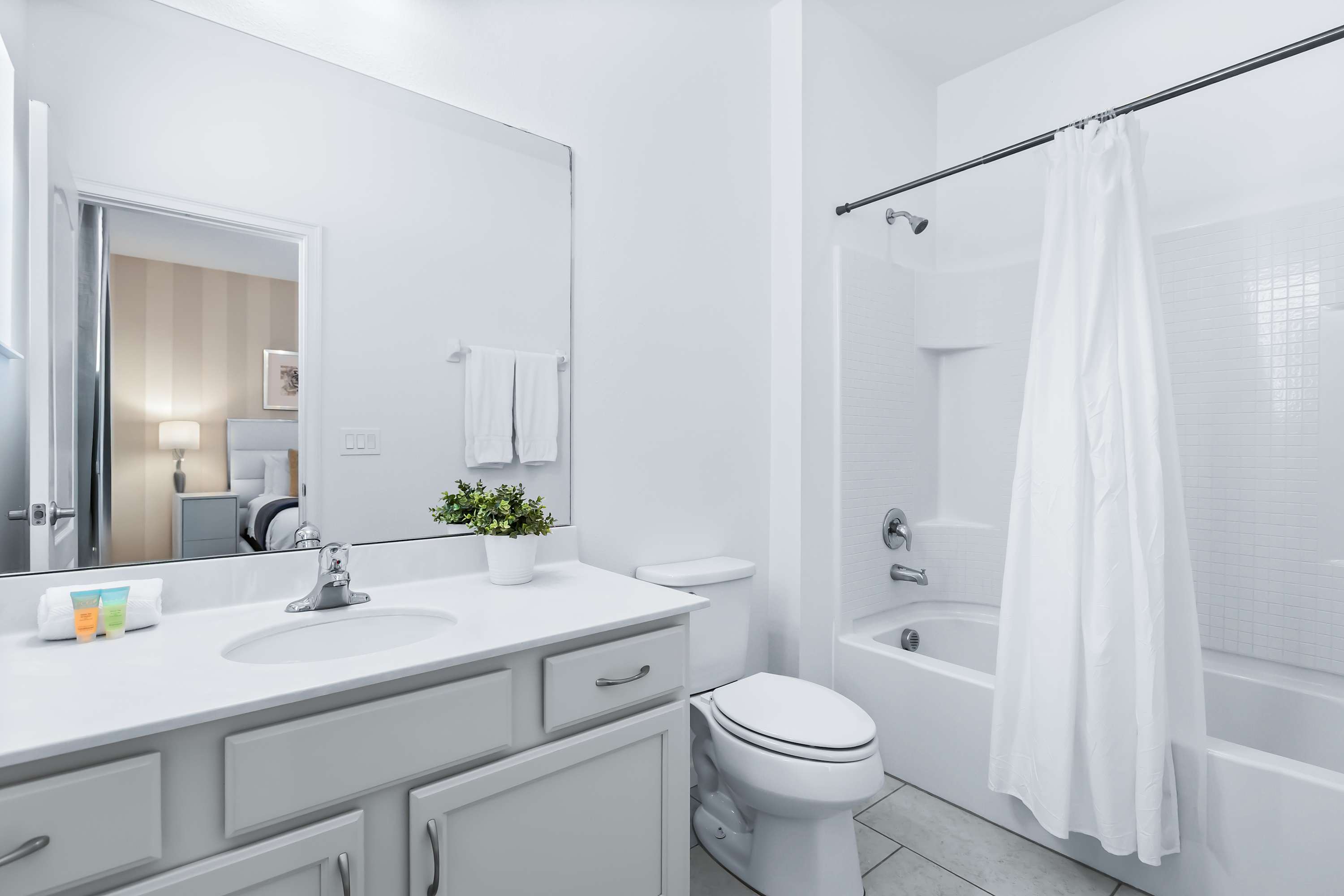 Bright bathroom with shower/tub combo and modern finishes.