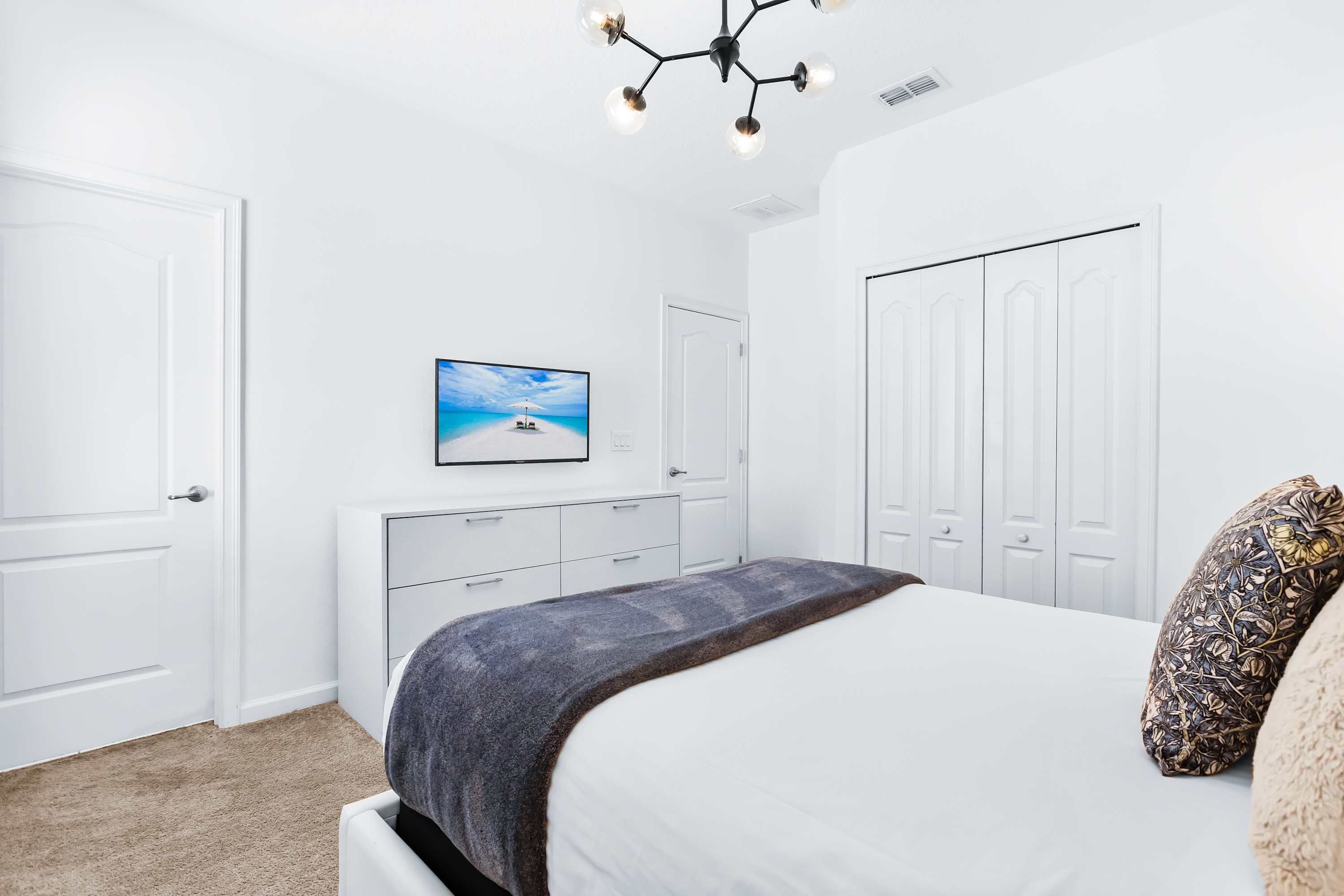 Bedroom with TV, cozy bedding, and minimalist design.