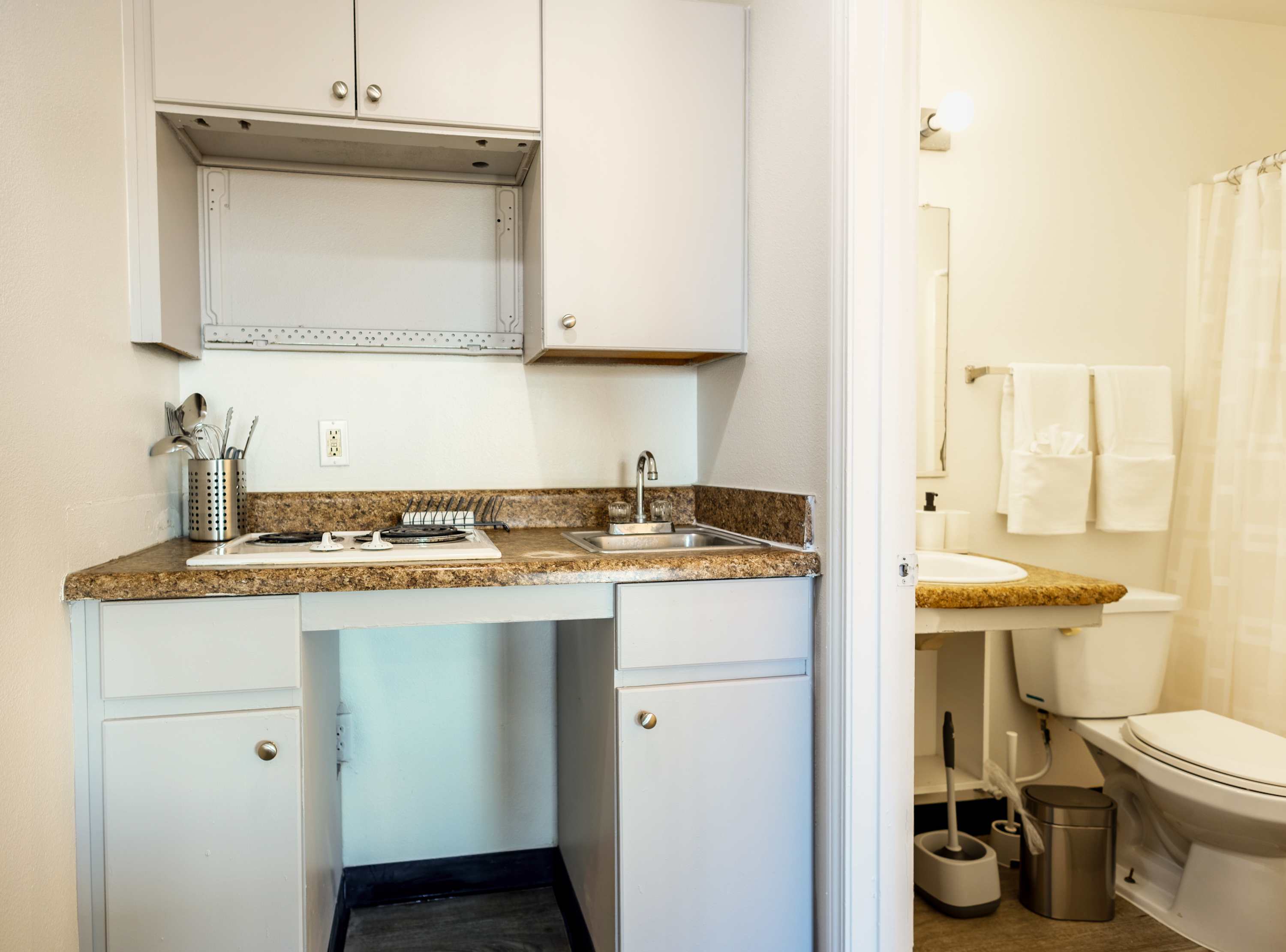 Cozy kitchenette and bathroom combo perfect for efficient living in a compact studio.