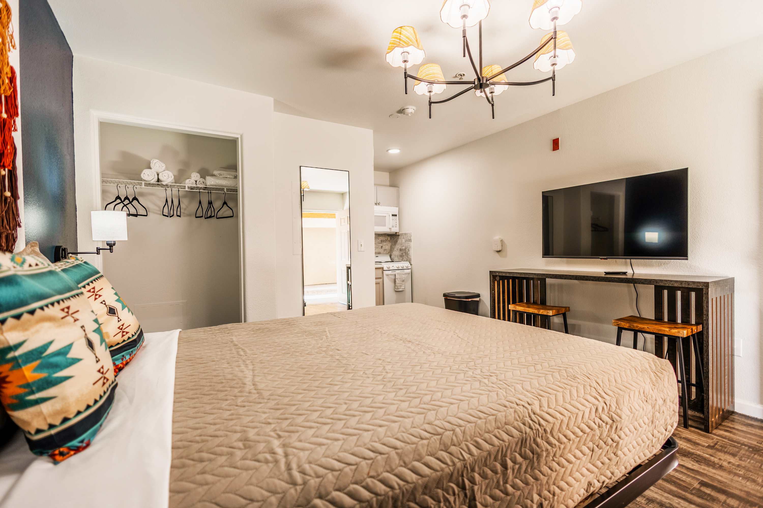 Relax in this cozy studio with a plush bed, modern kitchenette, and smart TV, perfect for a comfortable stay.