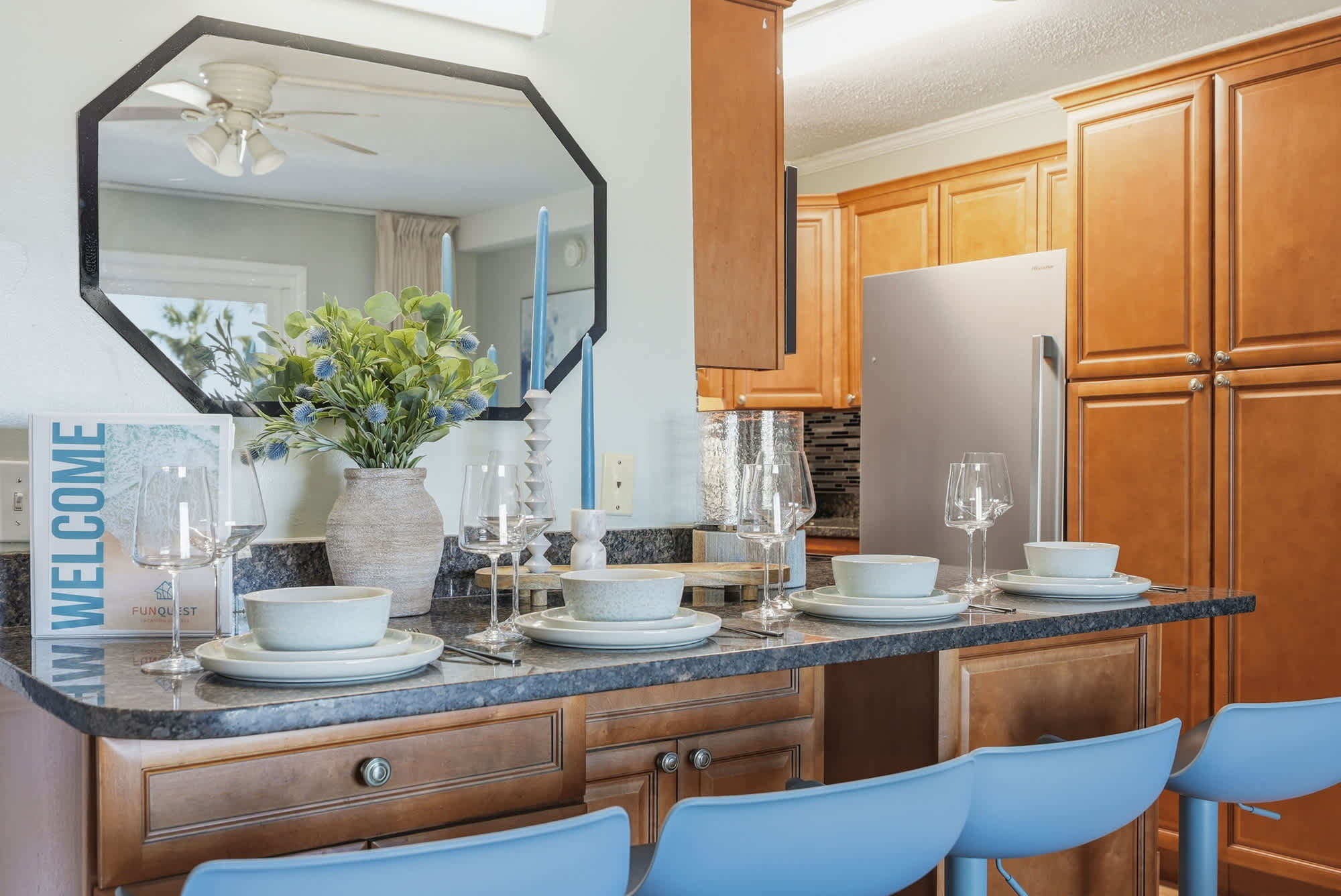 The Summit 131 – Dining area with wooden cabinets, blue bar stools, and a decorated table set with dishes and glasses.
