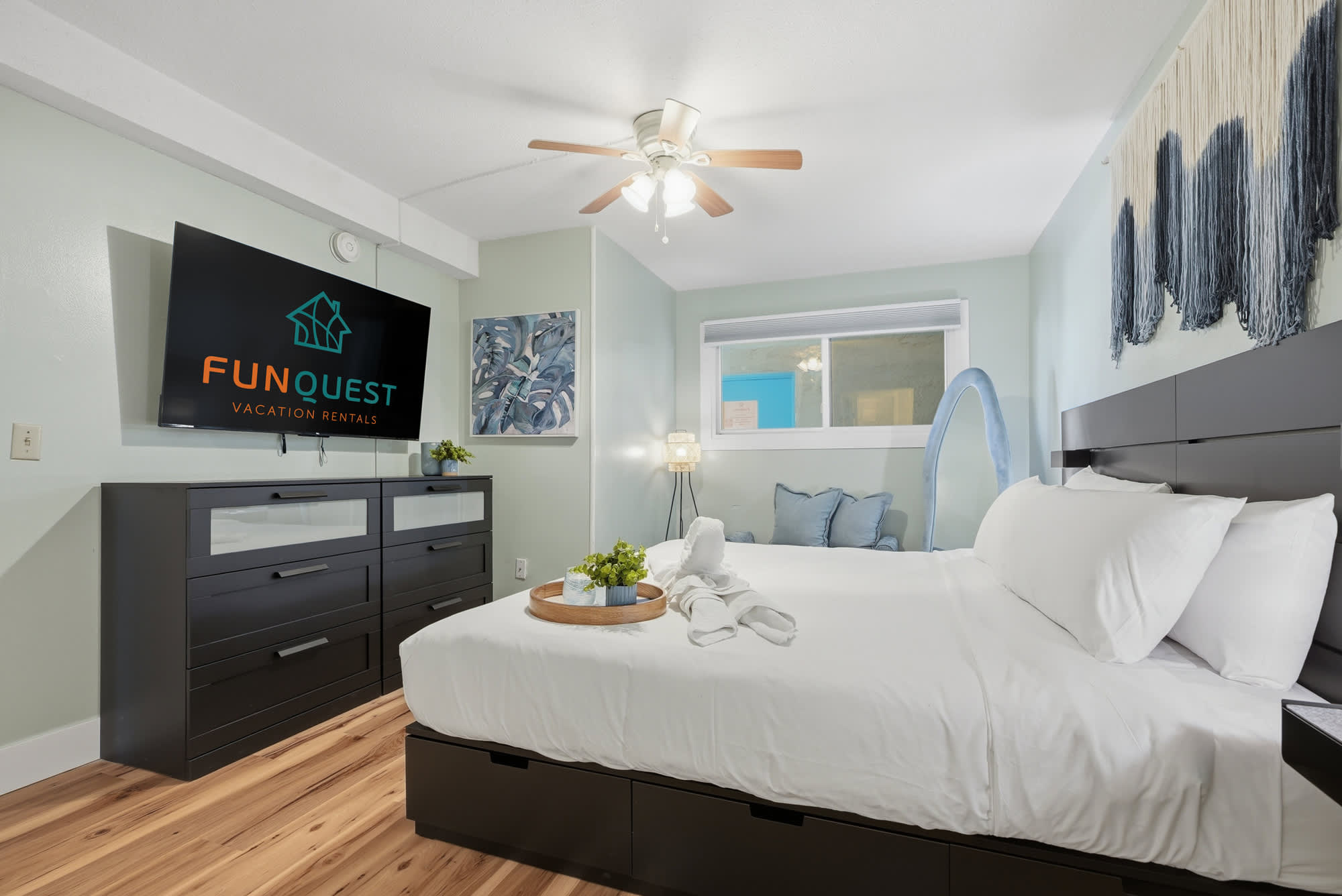 The Summit 131 – Cozy bedroom with a queen bed, television, dresser, and soft blue accents.