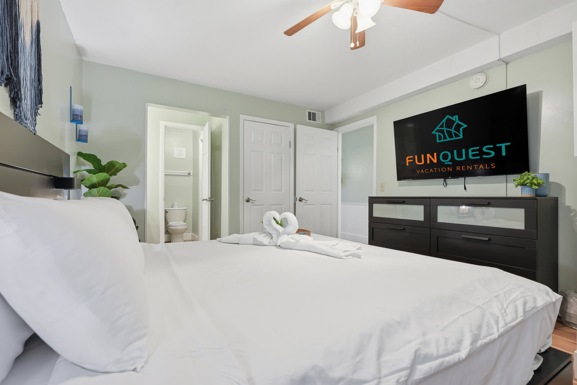 The Summit 131 – Bedroom with a queen bed, flat-screen TV, and connecting bathroom door visible.
