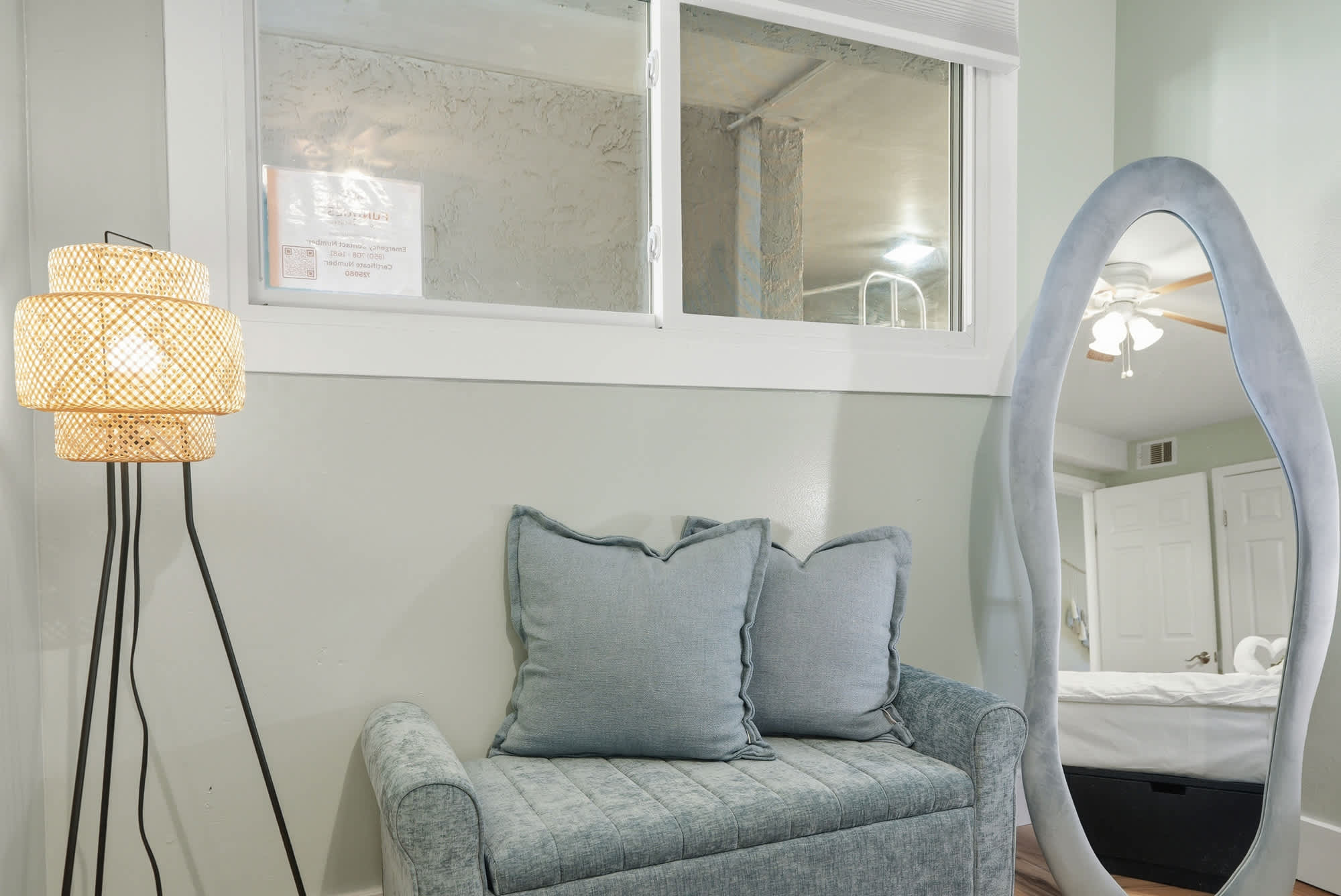 The Summit 131 – Cozy sitting area with a blue loveseat, decorative lamp, and a large mirror.
