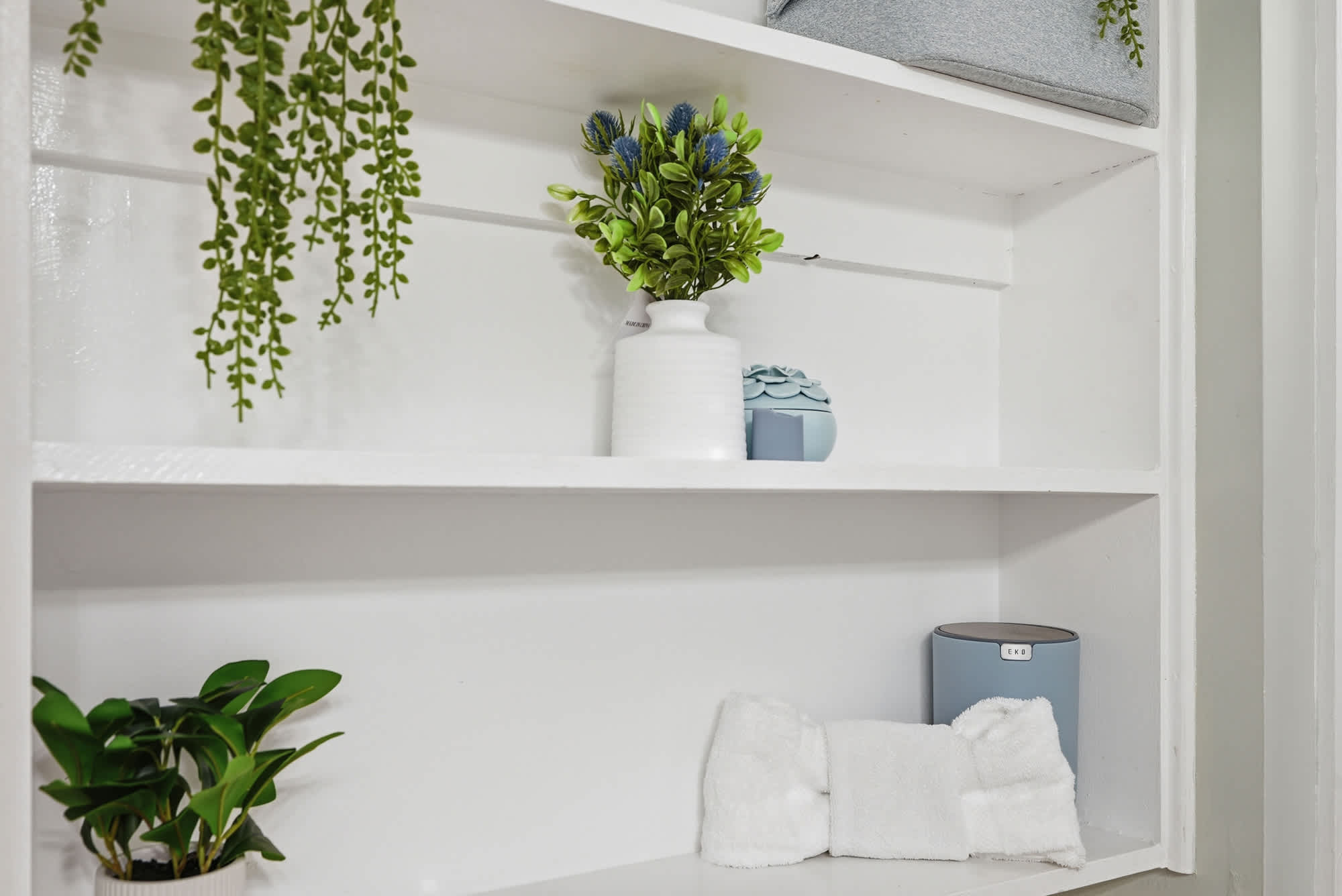 The Summit 131 – Open shelving with decorative plants, towels, and accessories in a bright, clean space.