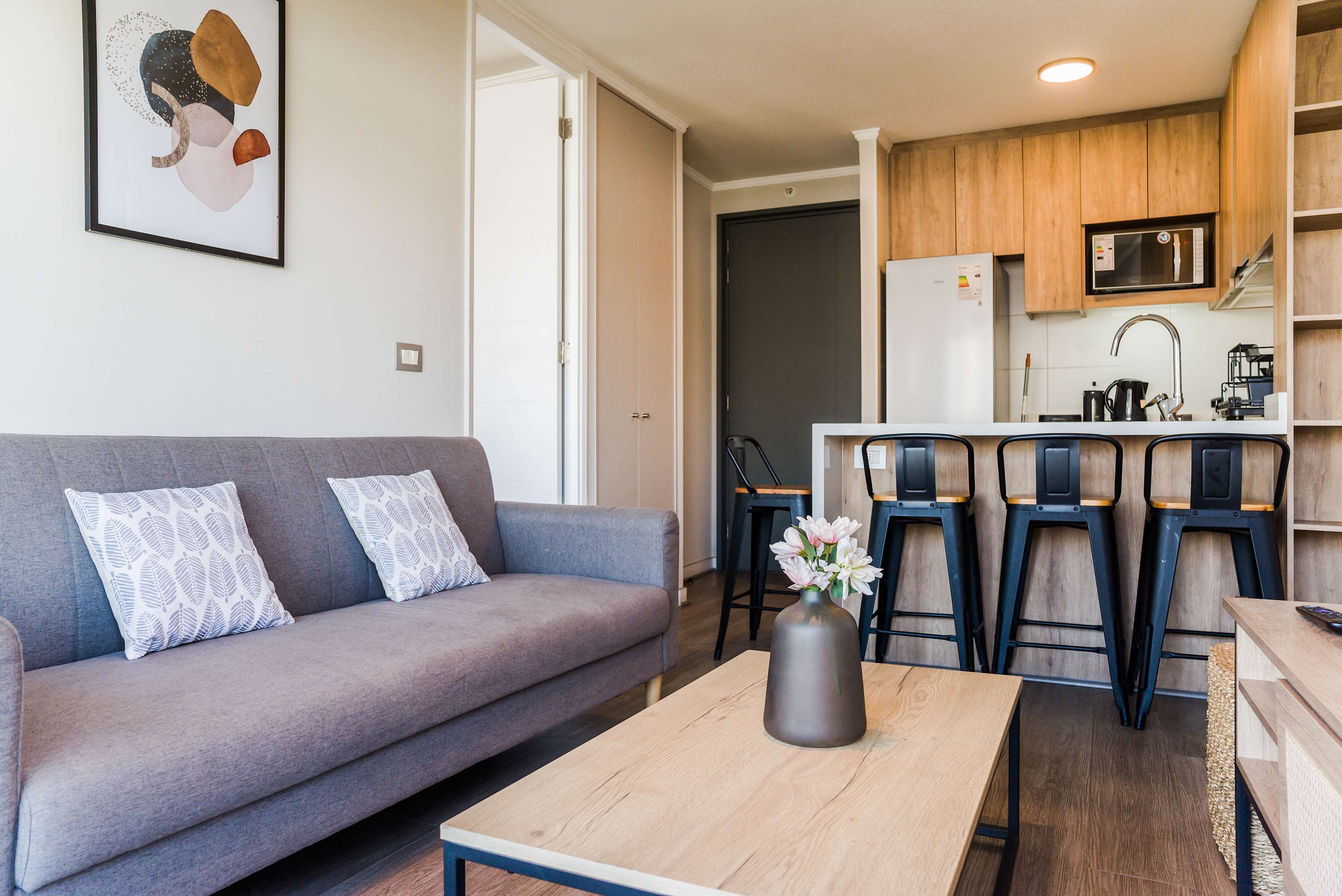Cozy and modern living area with a stylish kitchen and breakfast bar, perfect for relaxing or entertaining.