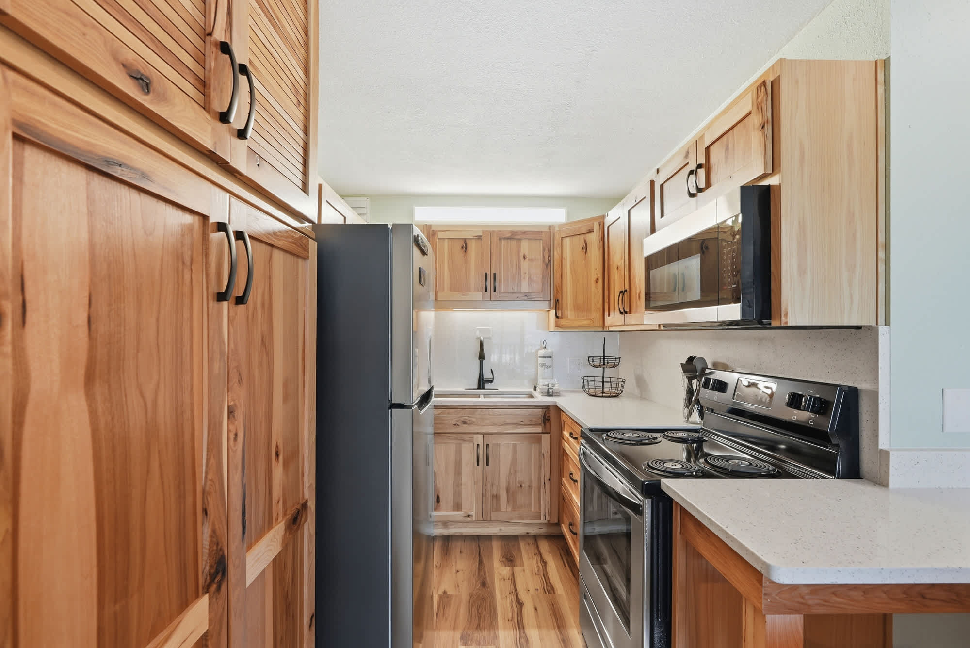 The Summit 206 – Modern kitchen with wooden cabinets, stainless steel appliances, and a countertop.