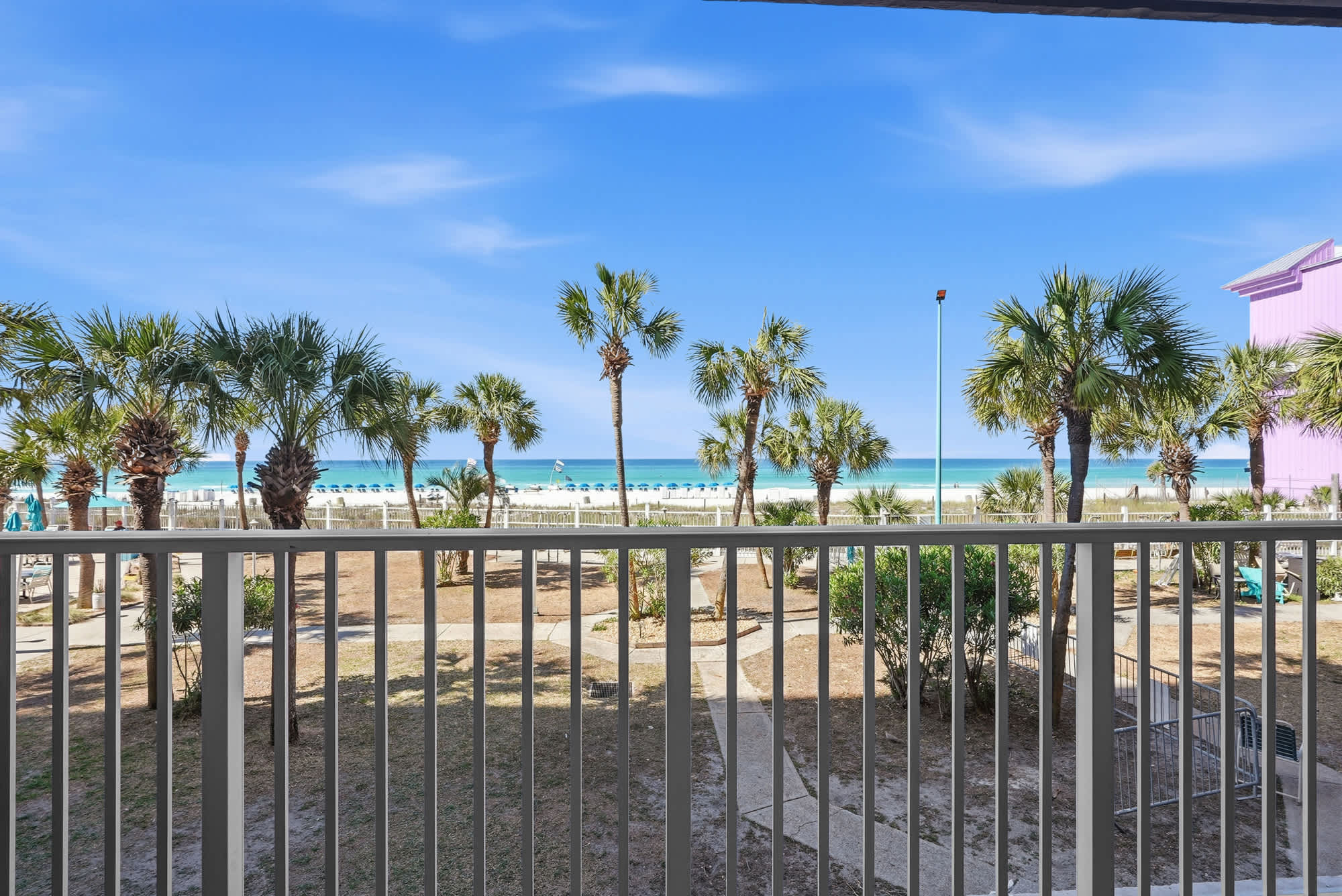 The Summit 206 – View from balcony with palm trees, beach, and ocean in the distance.