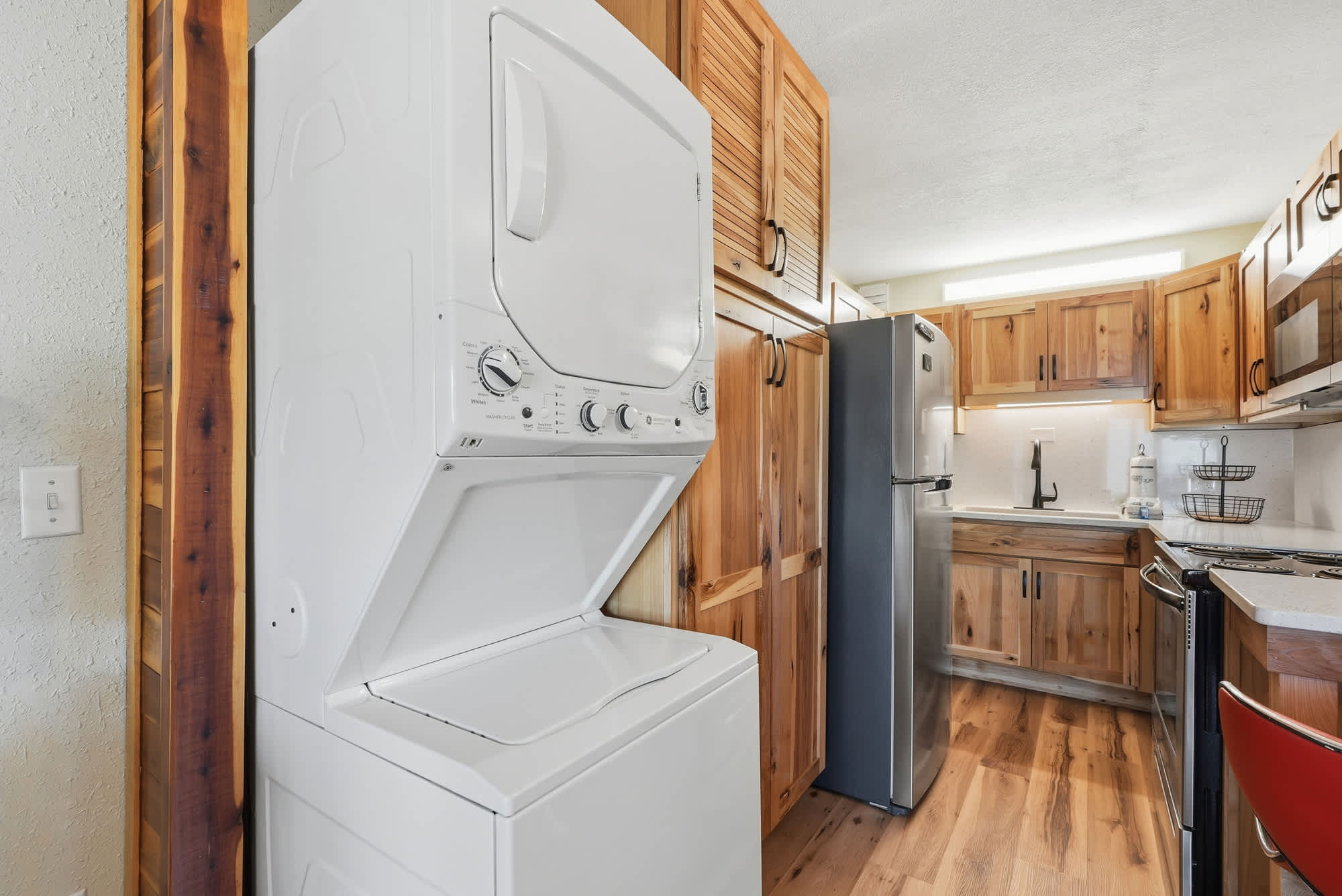 The Summit 206 – Laundry machine, wooden cabinets, stainless steel appliances, and countertop in a compact kitchen setting.