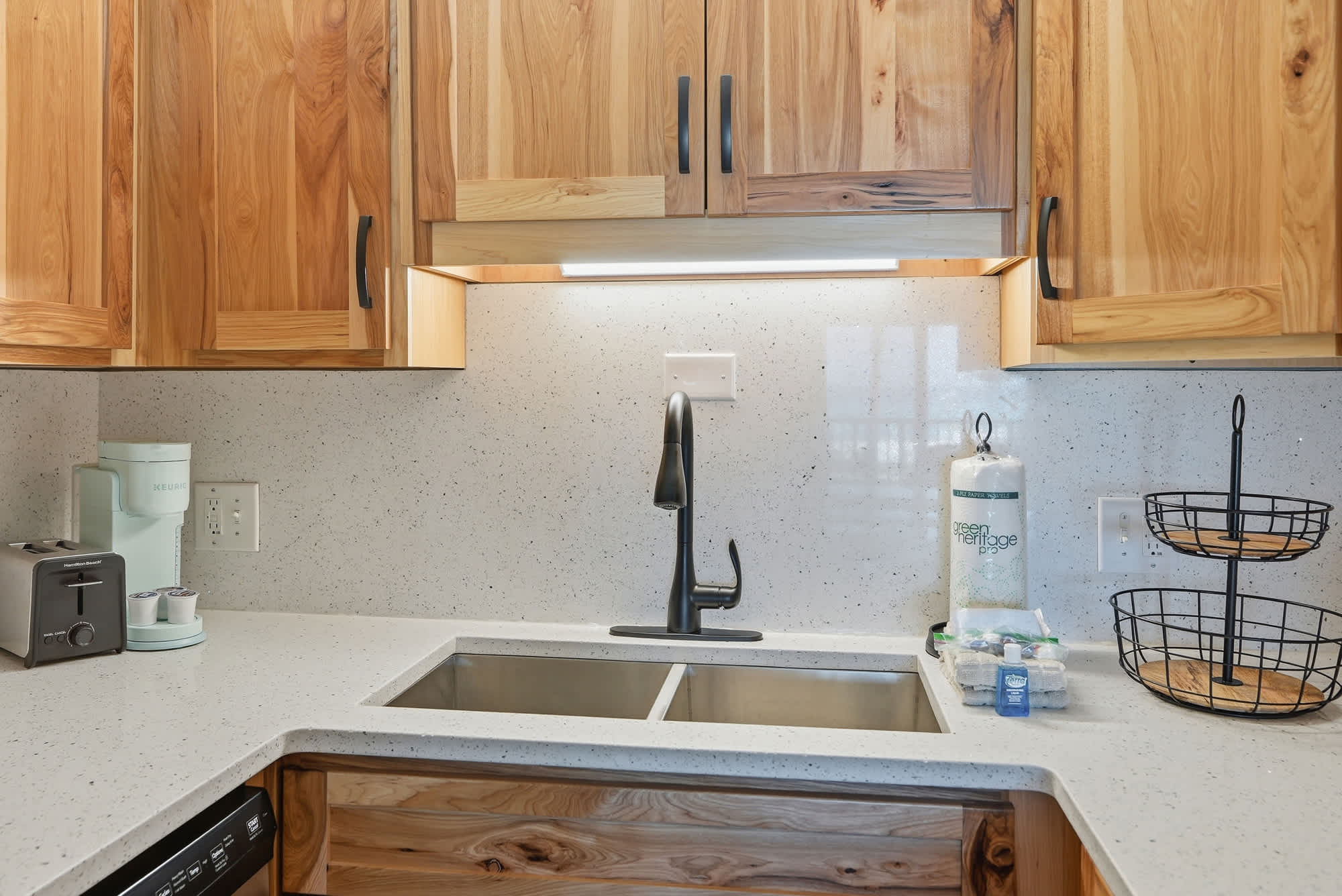 The Summit 206 – Modern kitchen with wood cabinetry, double sink, and appliances including a toaster and coffee maker.