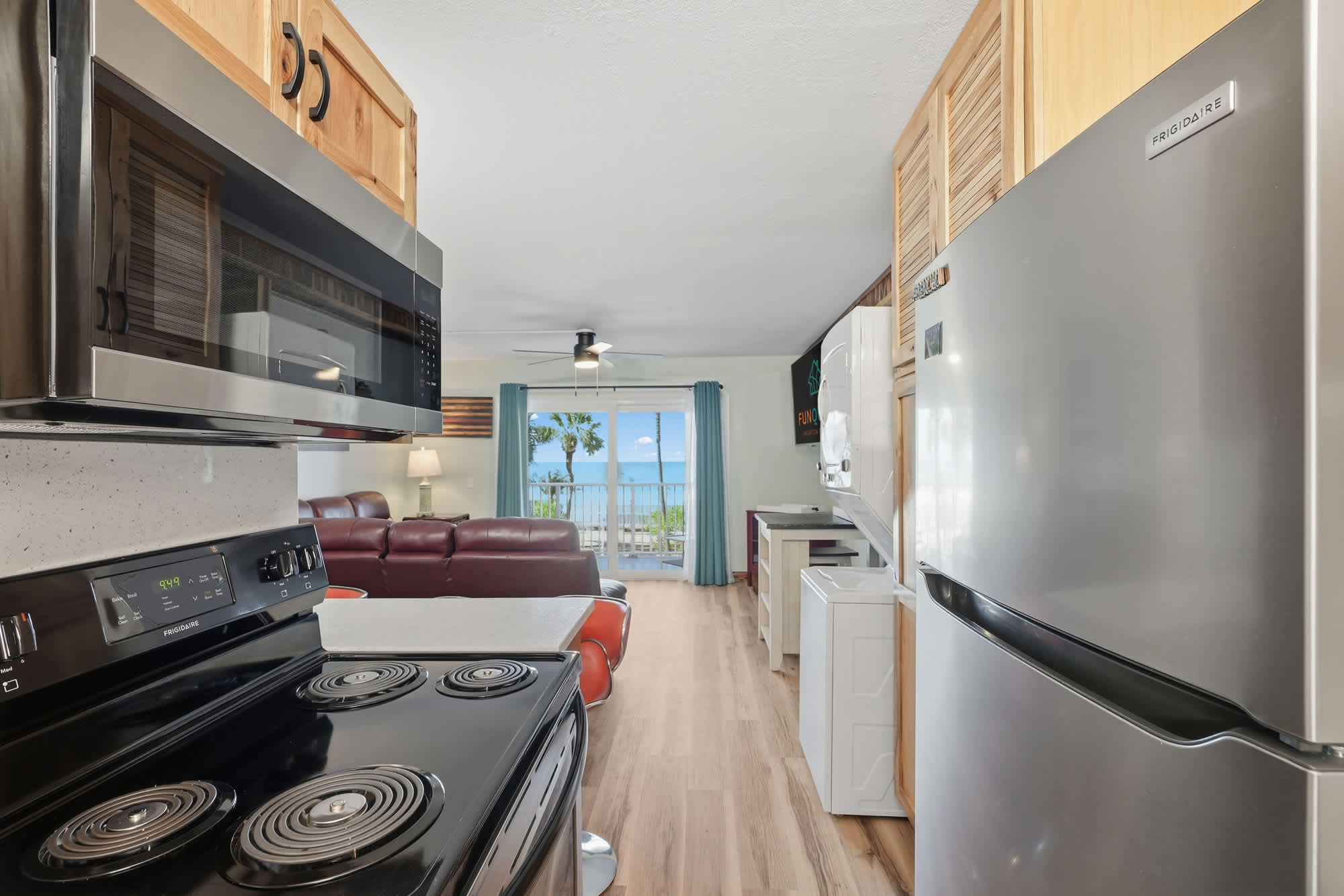 The Summit 206 – Open-concept kitchen and living area with ocean view, featuring stainless steel appliances and leather seating.