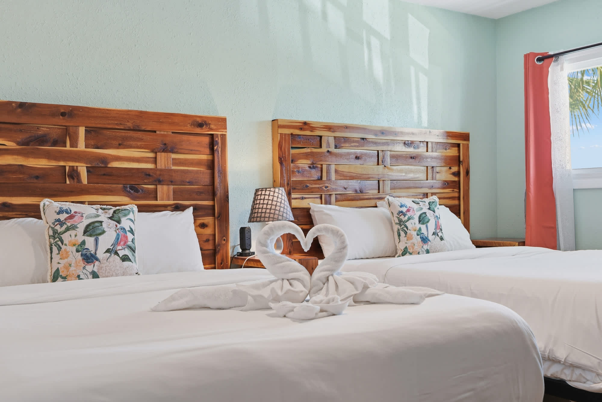 The Summit 206 – Room with two beds, wooden headboards, decorative pillows, and towel swans on the bed.