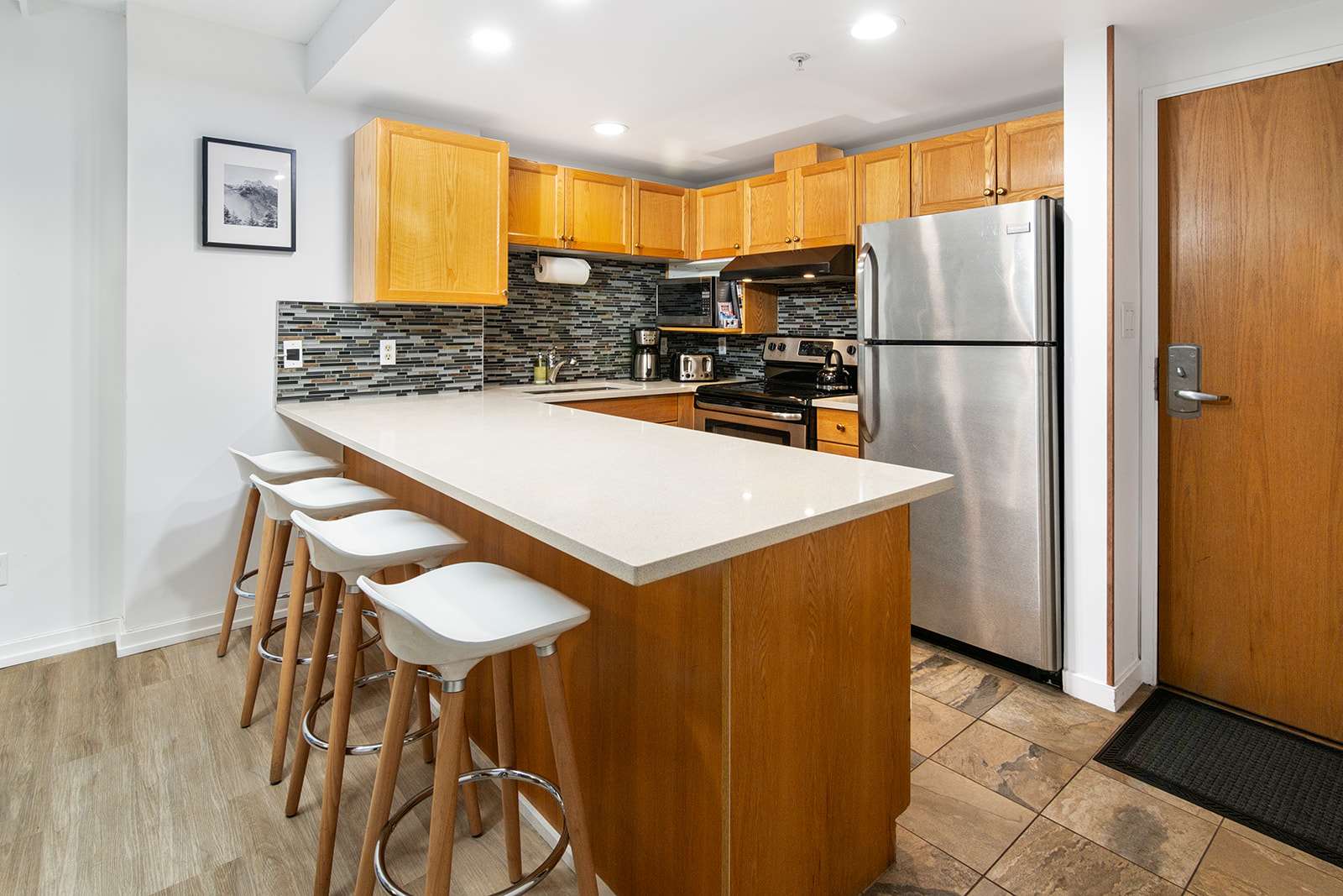 - Modern kitchen with stainless steel appliances and expansive counters - Stylish backsplash and lighting for a warm inviting atmosphere - Perfect for cooking meals or enjoying morning coffee before the slopes