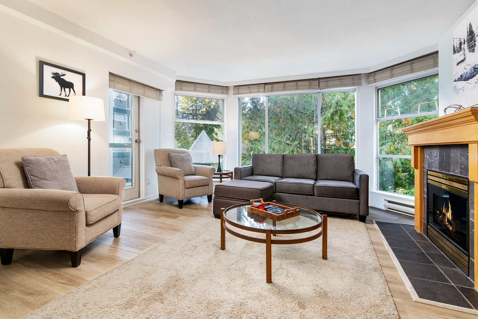 - Bright living room with mountain views and stone fireplace centerpiece - Plush seating and flat-screen TV create a cozy modern feel - Ideal space to unwind after skiing or hiking adventures in Whistler