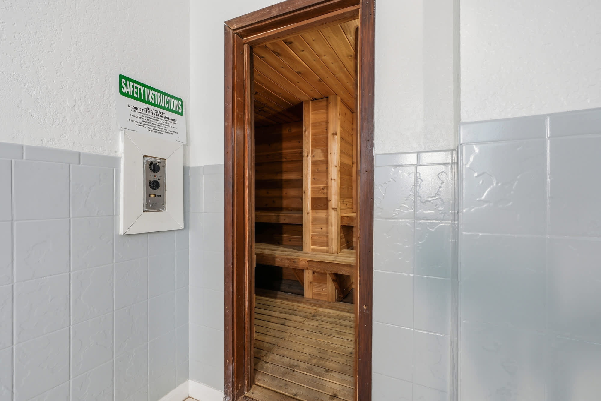 The Summit 531 – Entrance to a wooden sauna with safety instructions on the wall.