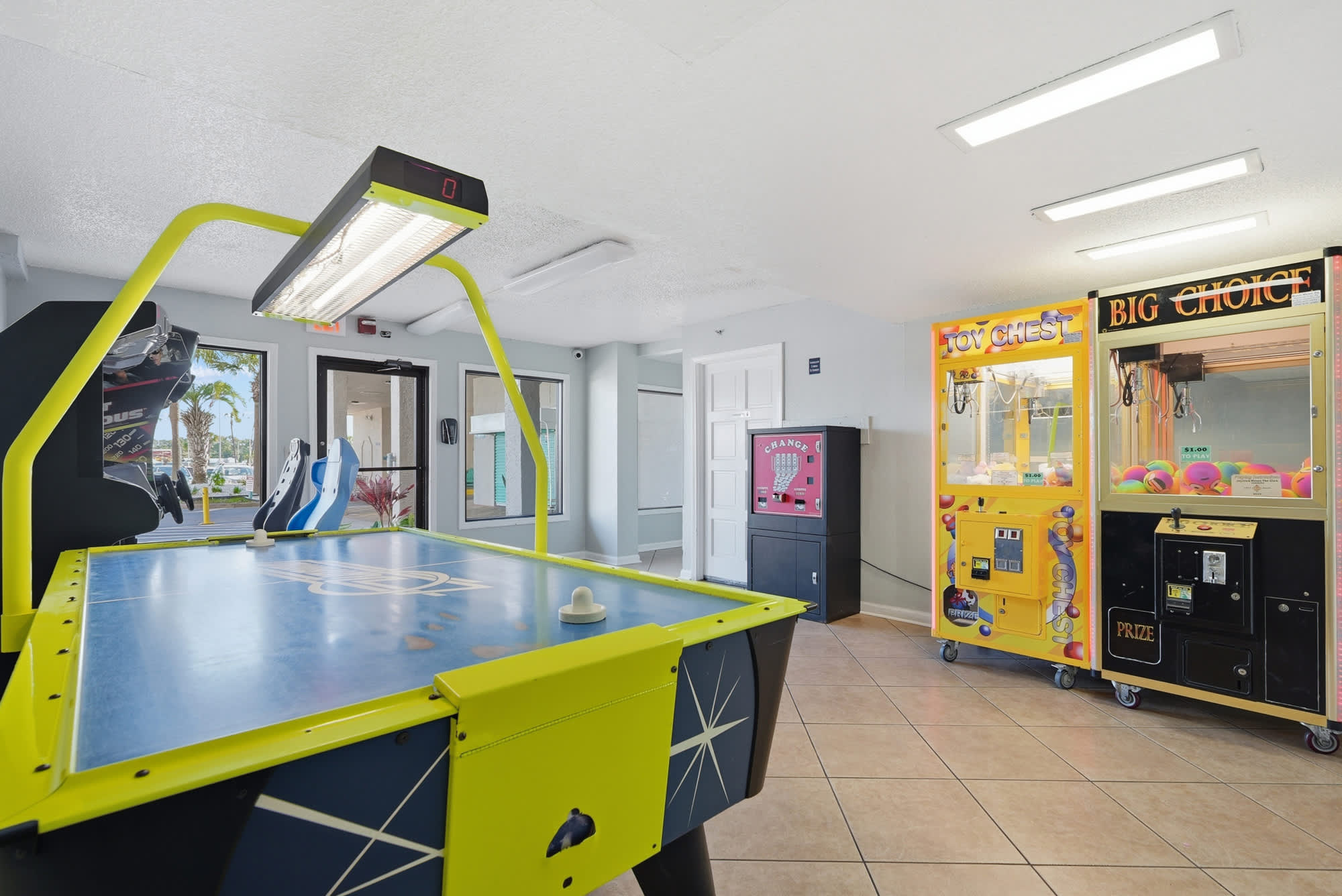 The Summit 618 – Game room featuring air hockey table, arcade machines, and a change machine.
