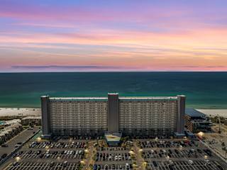 The Summit 1017 – Aerial view of The Summit 1017 rental with beach and ocean in the background at sunset.