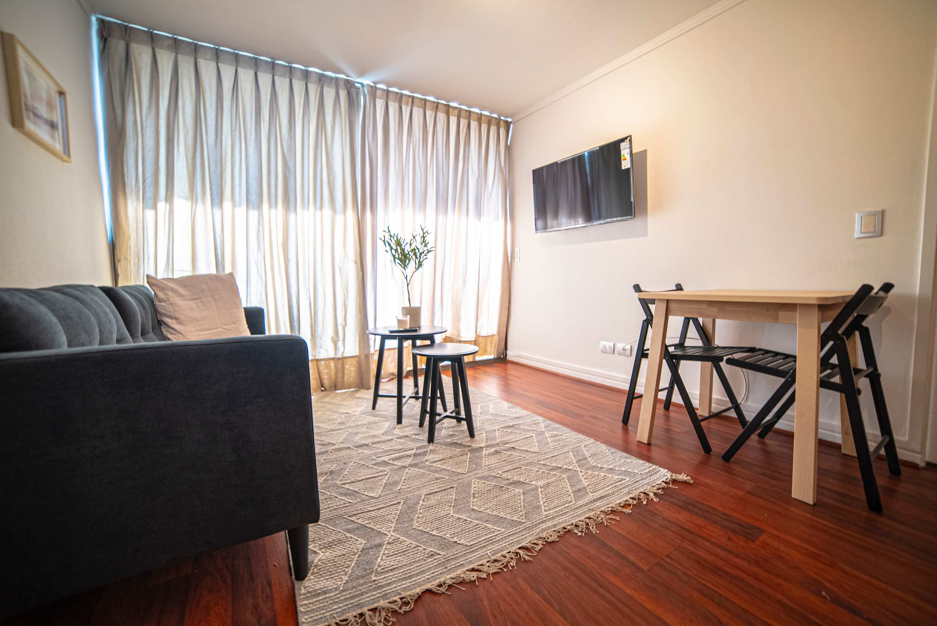 Cozy living space with a comfy sofa, dining area, and natural light, perfect for relaxation in your Chilean getaway.