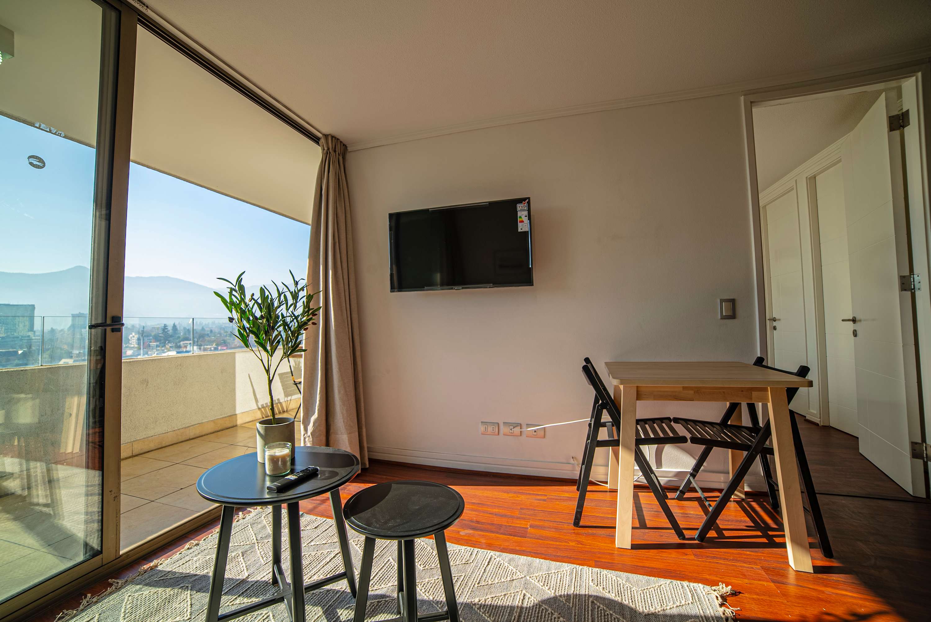 Bright and cozy living space with stunning mountain views from the balcony, perfect for relaxation.