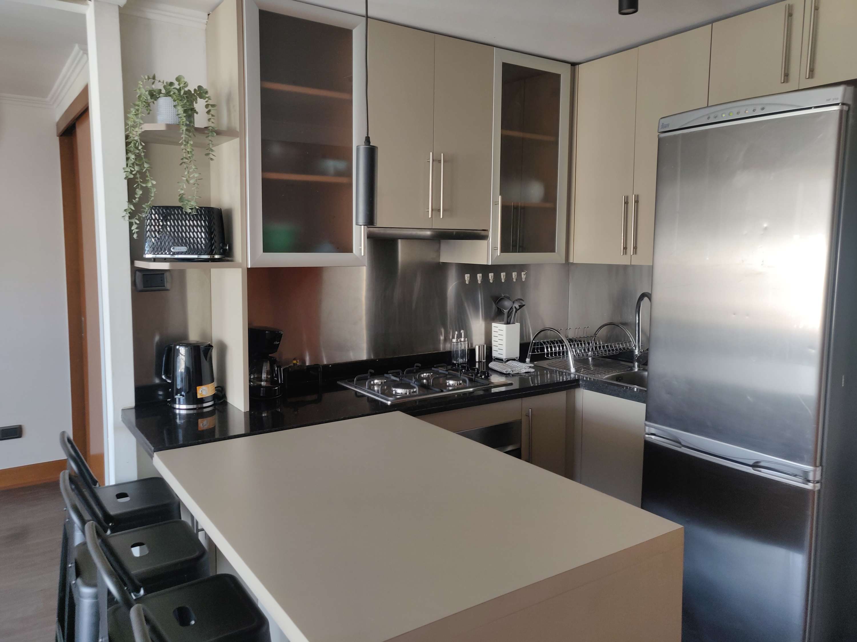 Sleek and modern kitchen with stainless steel appliances and a cozy breakfast bar, perfect for enjoying meals during your stay.