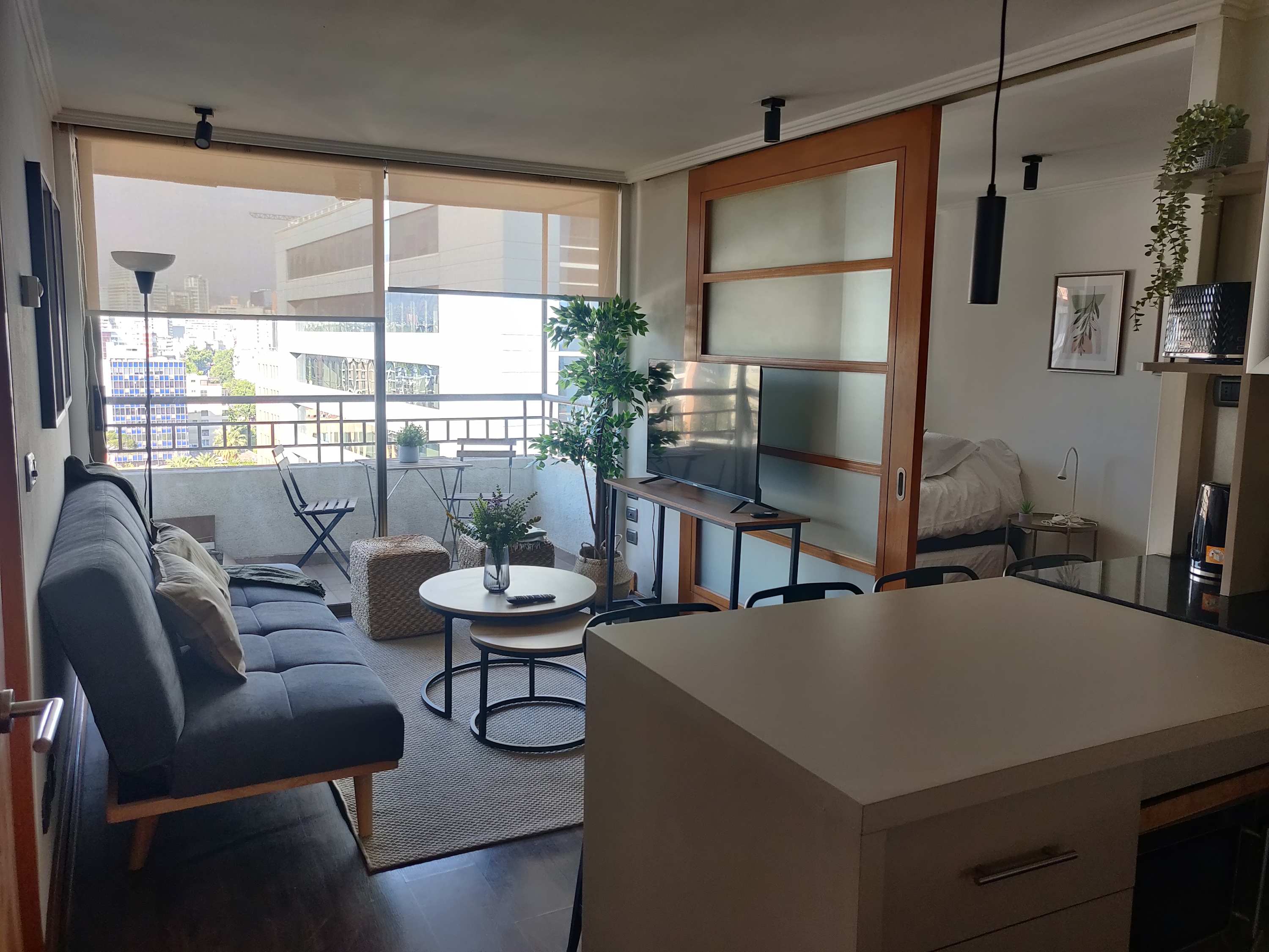 Cozy living area with a balcony view, perfect for relaxation in the heart of the city.
