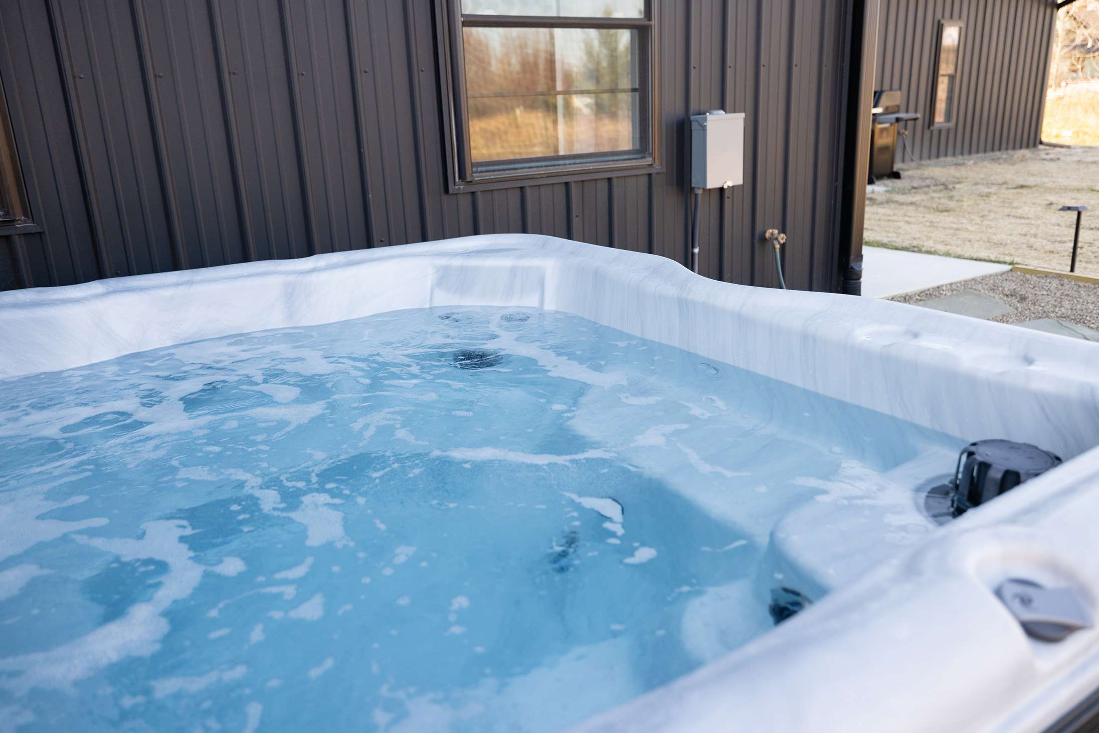 Indulge in a warm soothing soak in your private outdoor hot tub retreat.