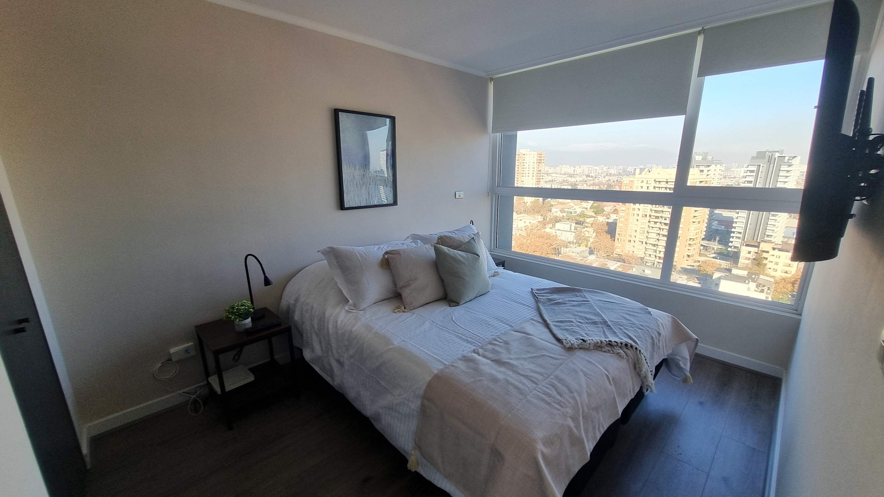 Relax in a cozy bedroom with stunning city views and modern amenities, perfect for unwinding after a day of exploring.