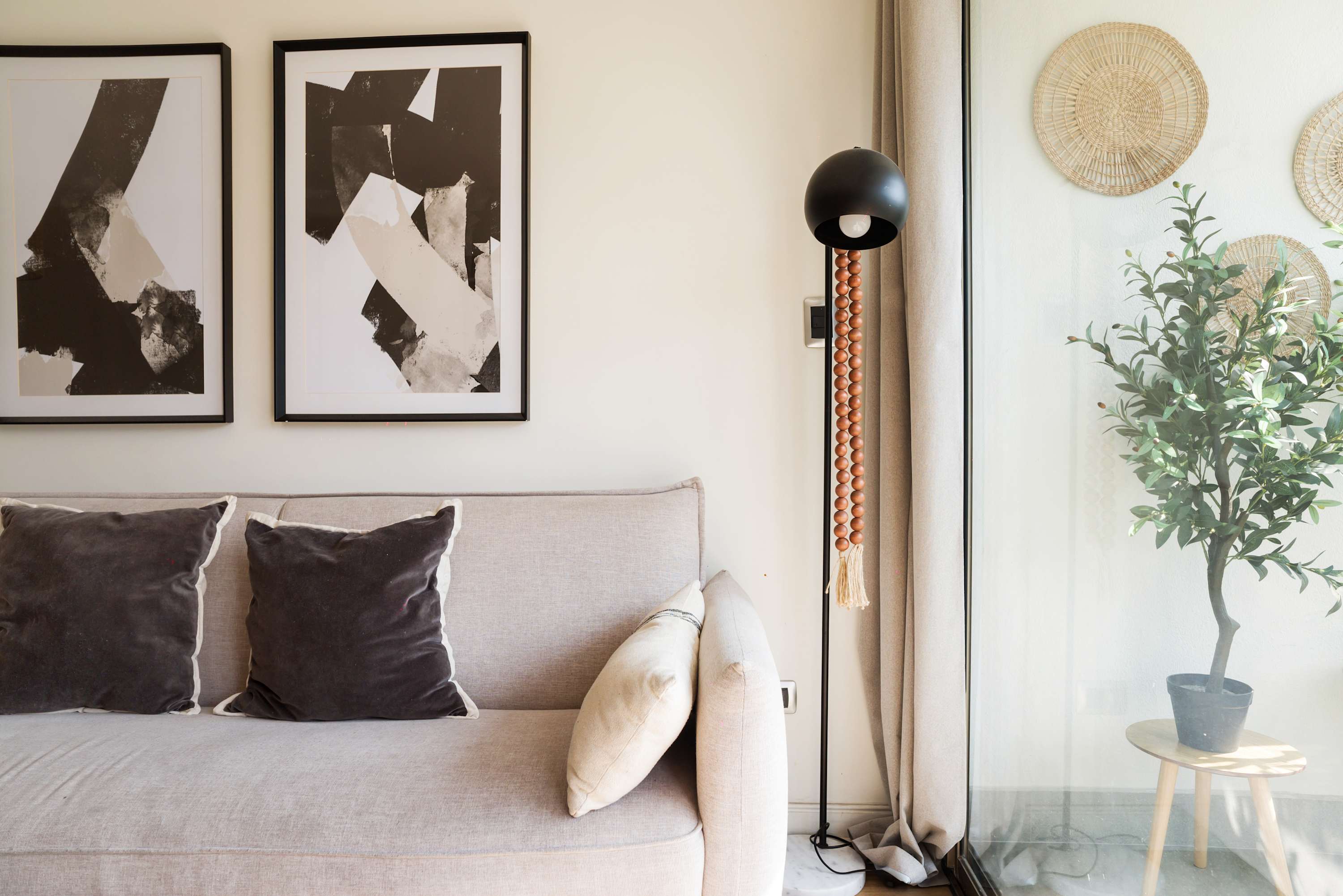 Relax in this stylish living room with modern art and a serene outdoor view.