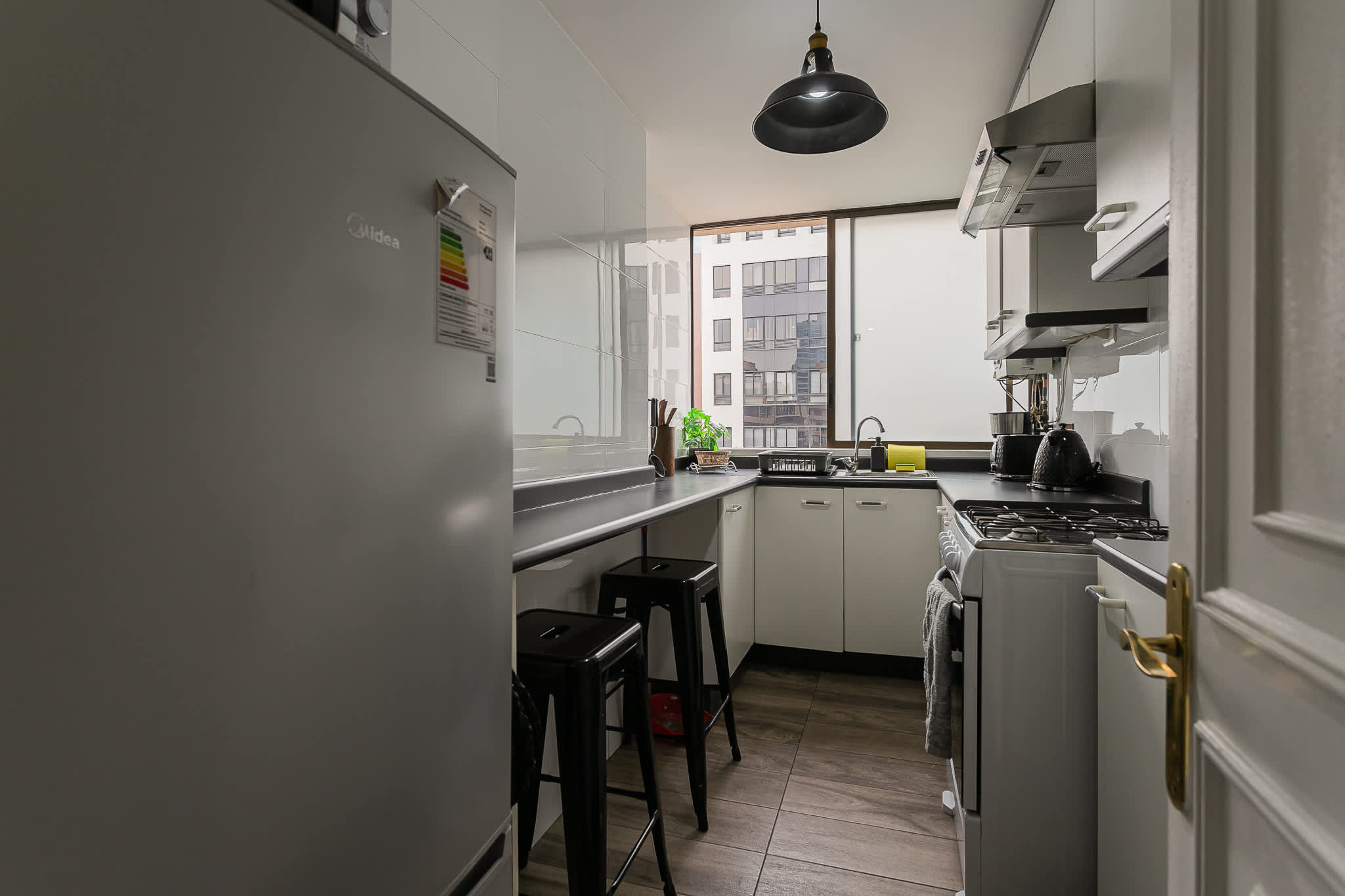 Sleek and modern kitchen with ample natural light, perfect for culinary enthusiasts.