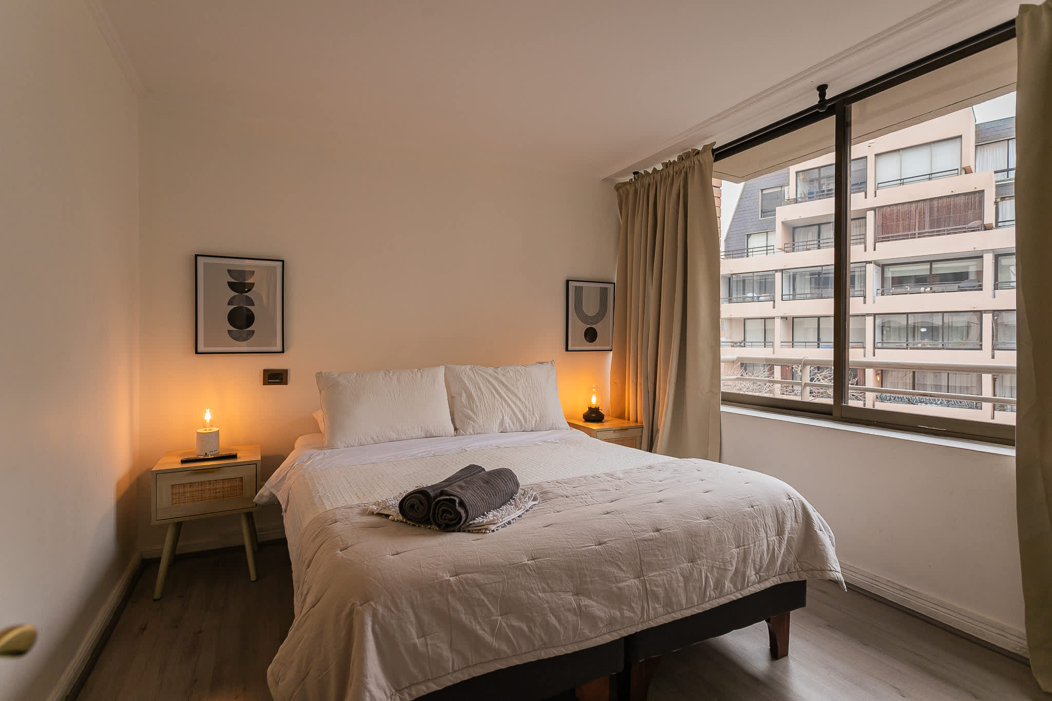 Relax in this cozy bedroom with a comfortable bed and a view of the cityscape.