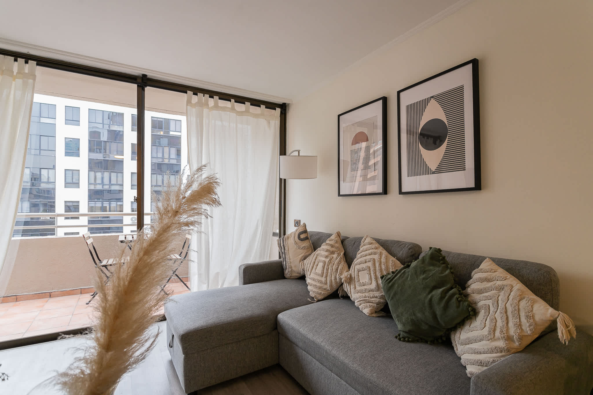 Relax in this stylish living room with a comfy sectional sofa and access to a charming balcony, perfect for morning coffee.