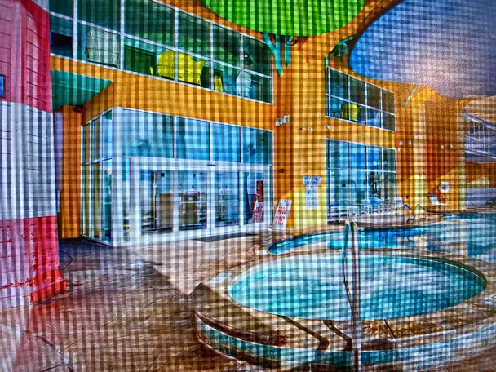 Splash 804E – Outdoor pool area with a hot tub and large windows. Brightly colored walls and palm trees visible.