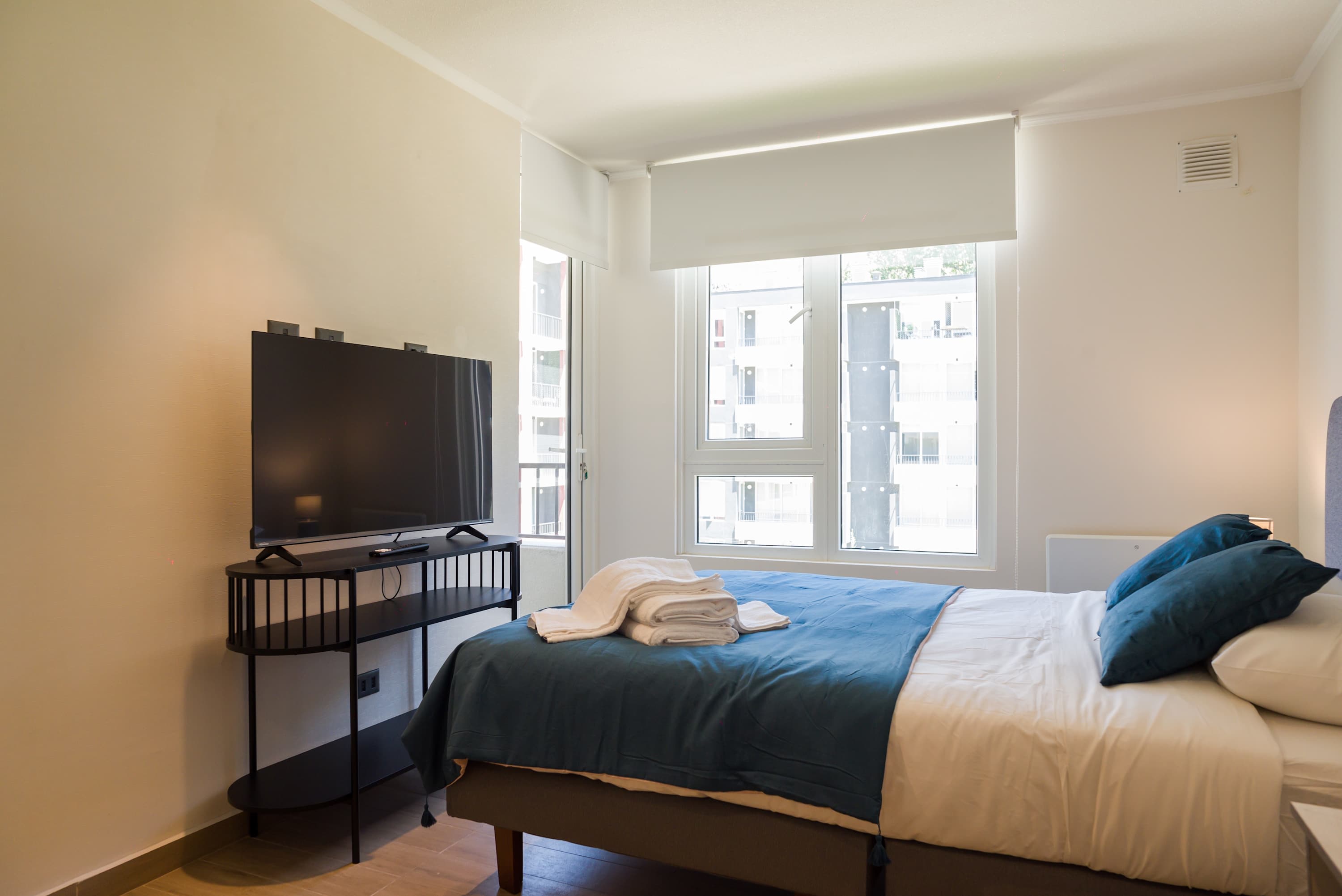 Cozy bedroom with natural light and modern amenities, perfect for relaxation after exploring the city.