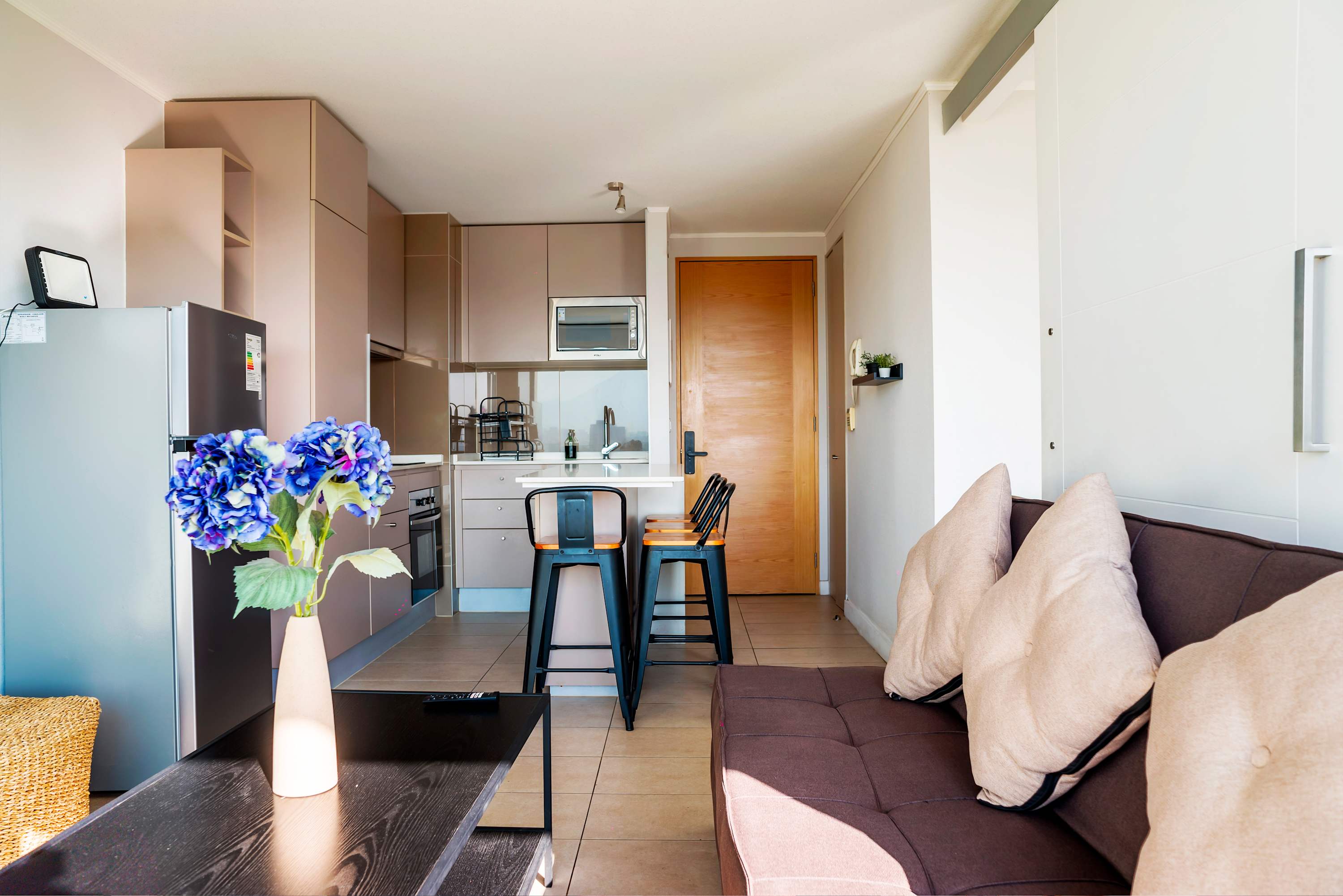 Cozy studio kitchen with modern amenities and a comfy seating area, perfect for a relaxing stay.