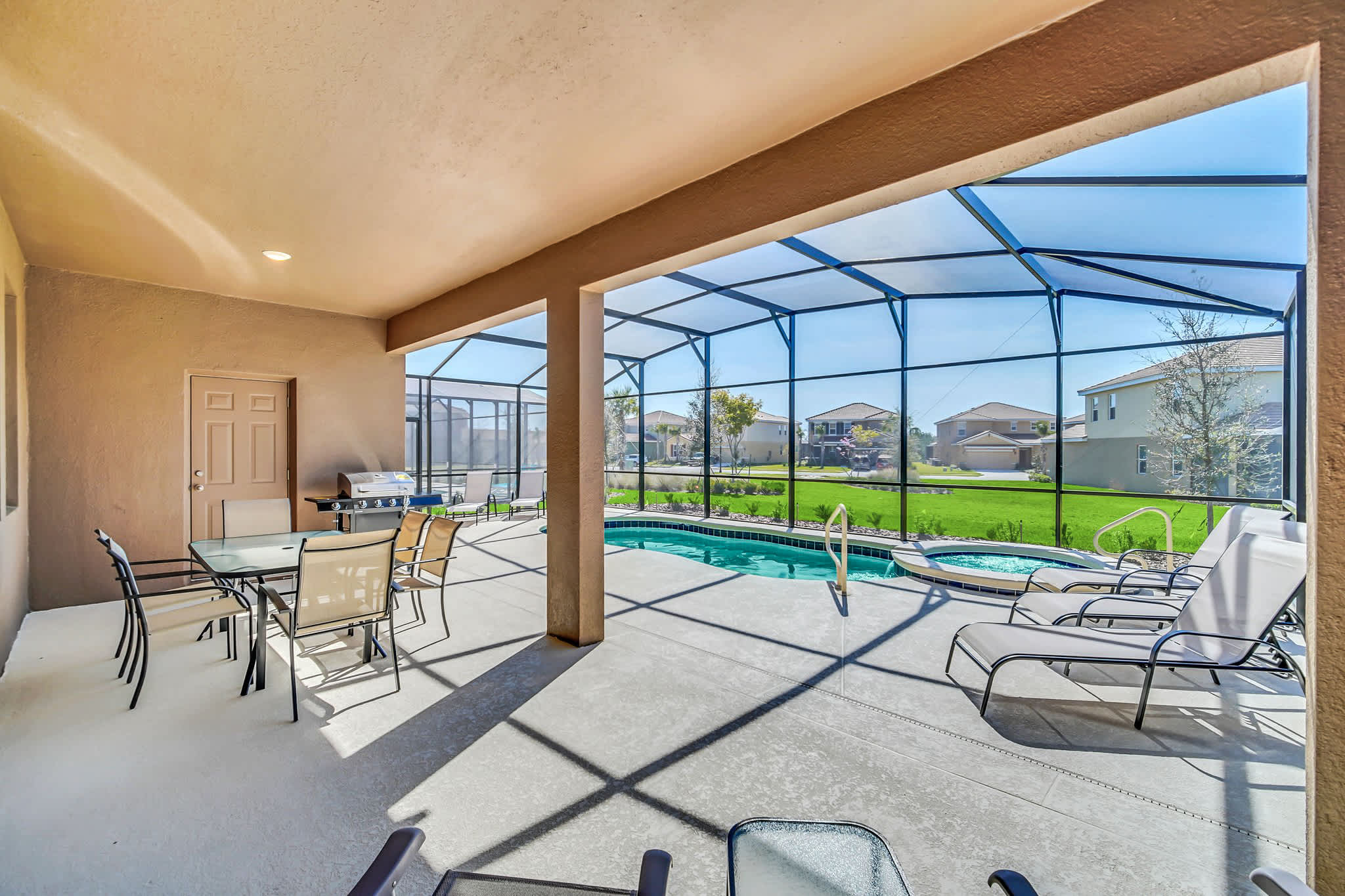 Enjoy your private screened patio with a pool and hot tub, ideal for family gatherings and sunbathing in a serene setting.
