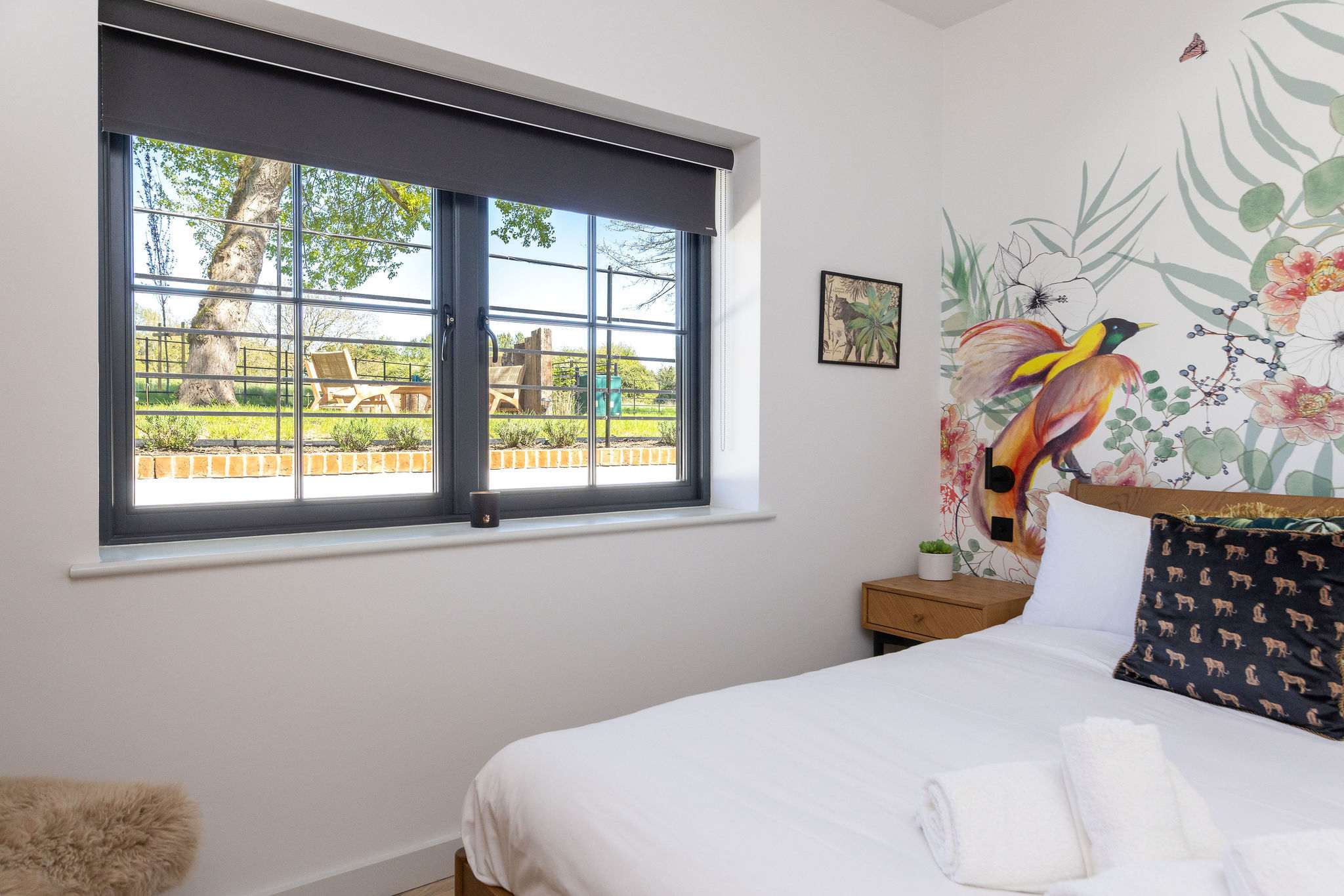 Wake beside leafy views, crisp linens, and cheerful wall art for a gentle Sussex escape.