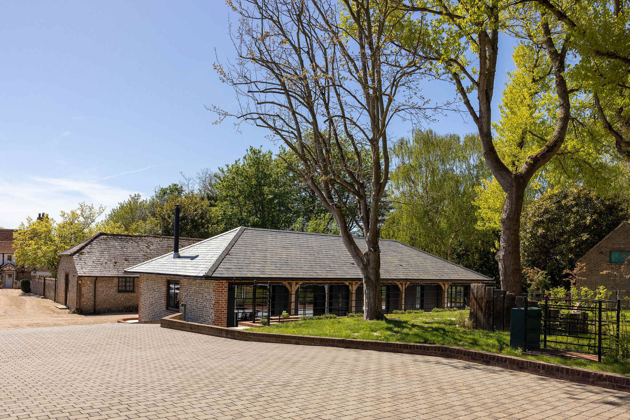 Arrive easily to a private gravel courtyard, framed by timber details and leafy rural surroundings.
