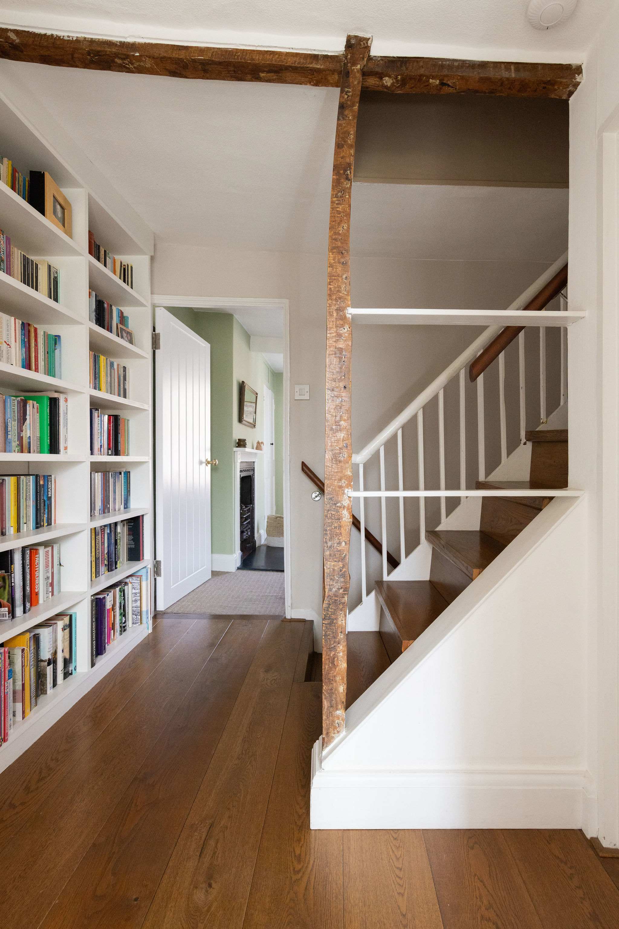 Characterful landing with exposed beams and built-in bookshelves