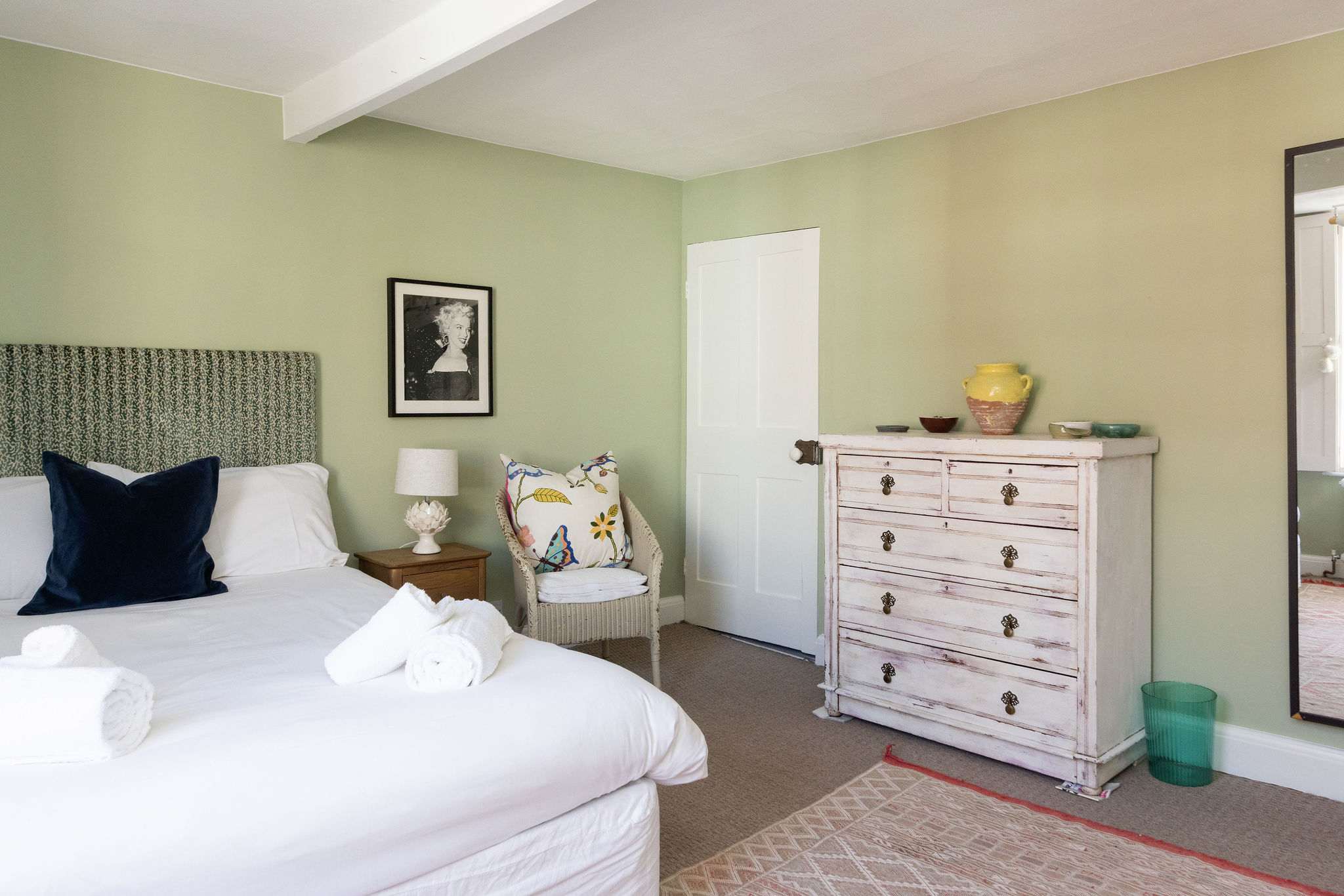 Spacious green bedroom with fireplace and calming vintage style