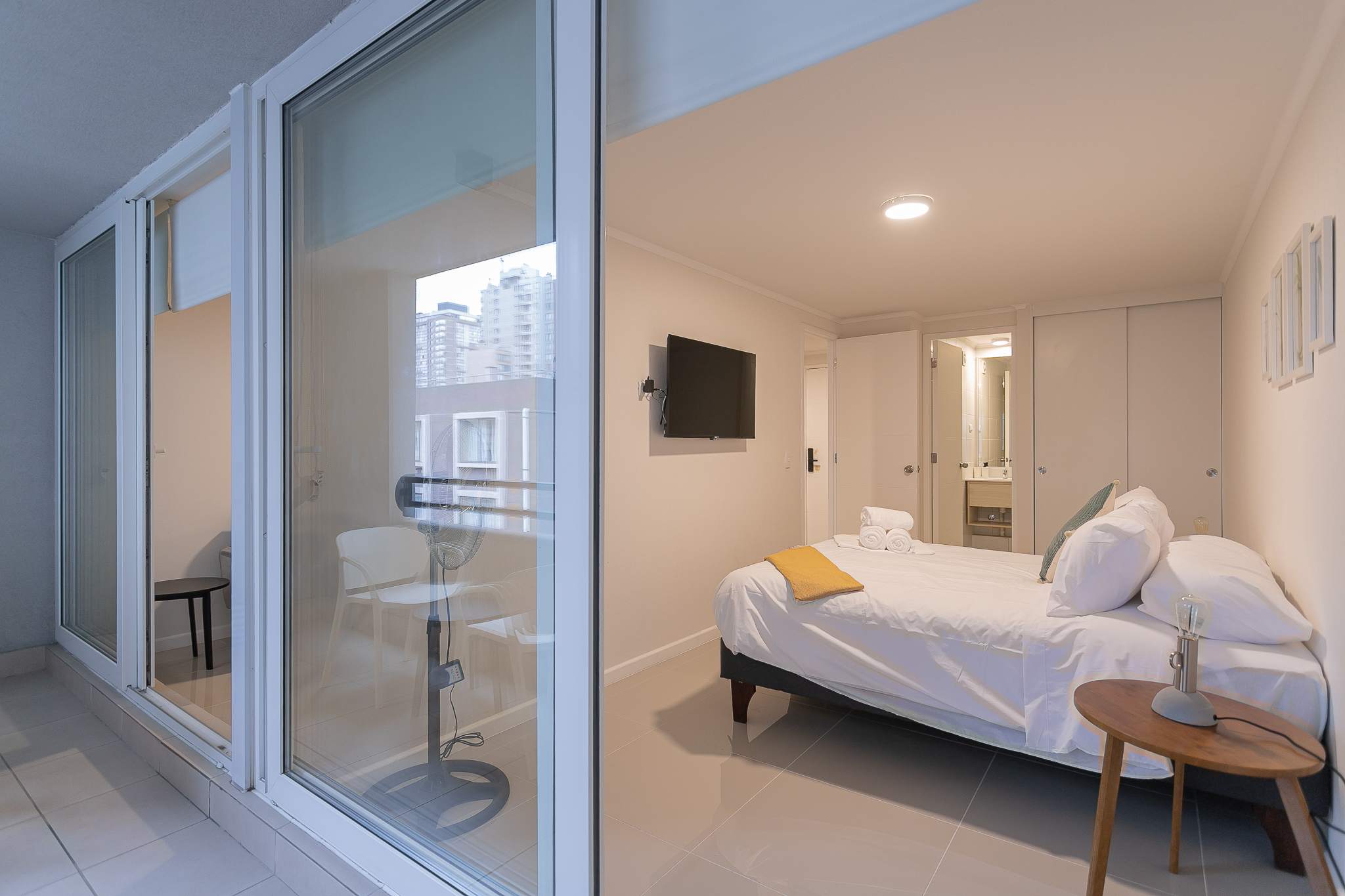 Cozy bedroom with balcony access and city views, perfect for relaxation in the heart of the city.