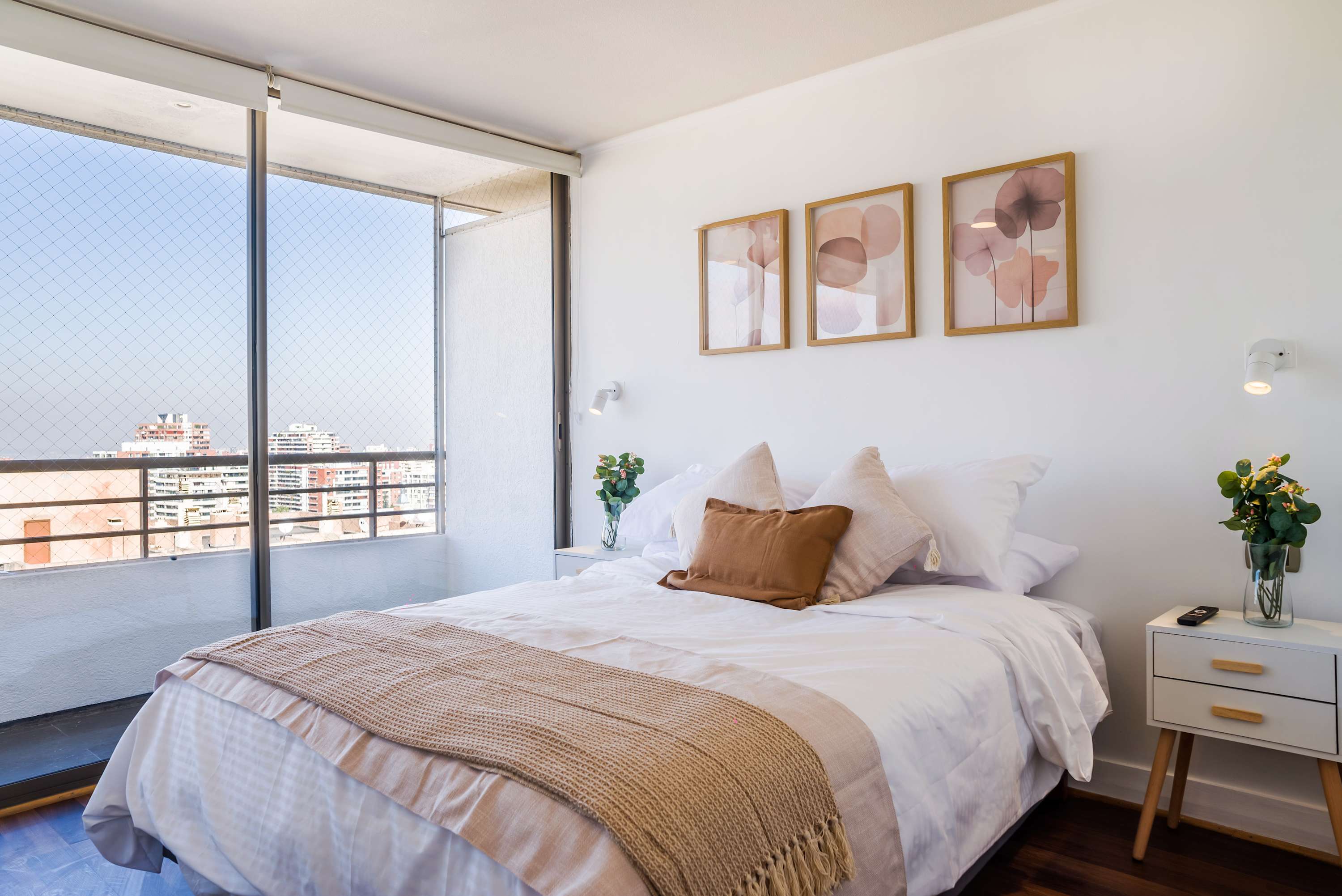 Relax in this cozy bedroom with stunning city views and stylish decor, perfect for a peaceful stay.