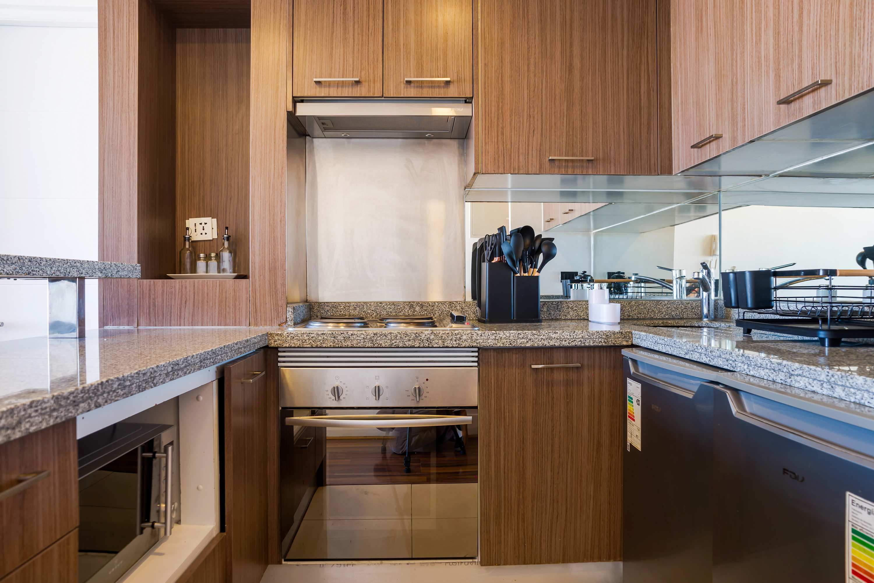 Modern kitchen with sleek wooden cabinetry and granite countertops, perfect for preparing meals in style.
